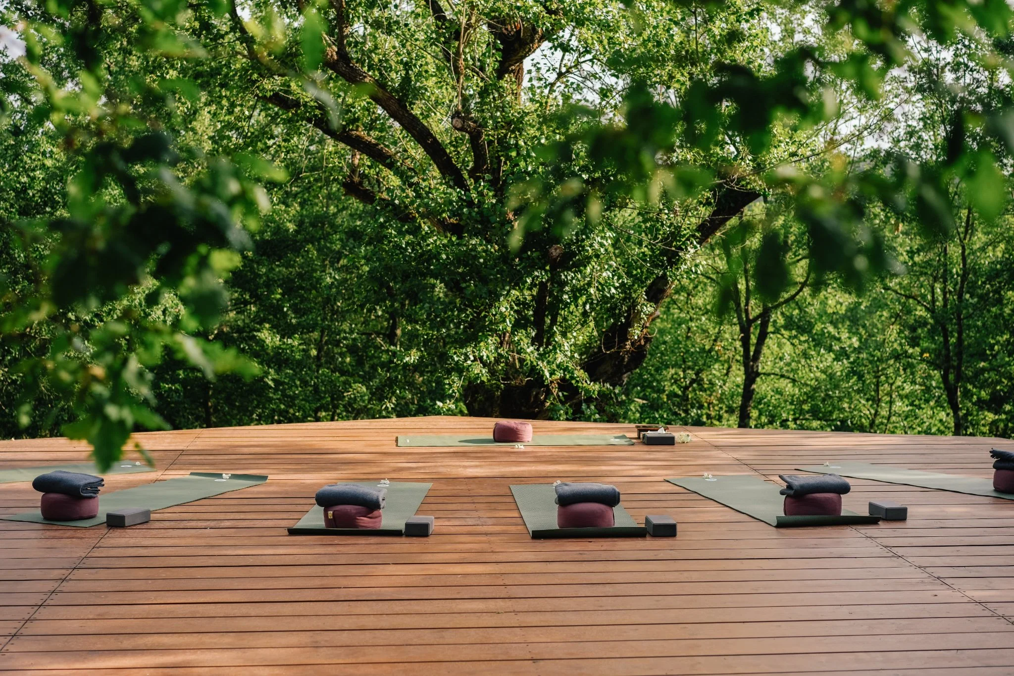 Morning yoga practice in an open-air deck at the I Am That Studio Italy retreat in Umbria, Italy
