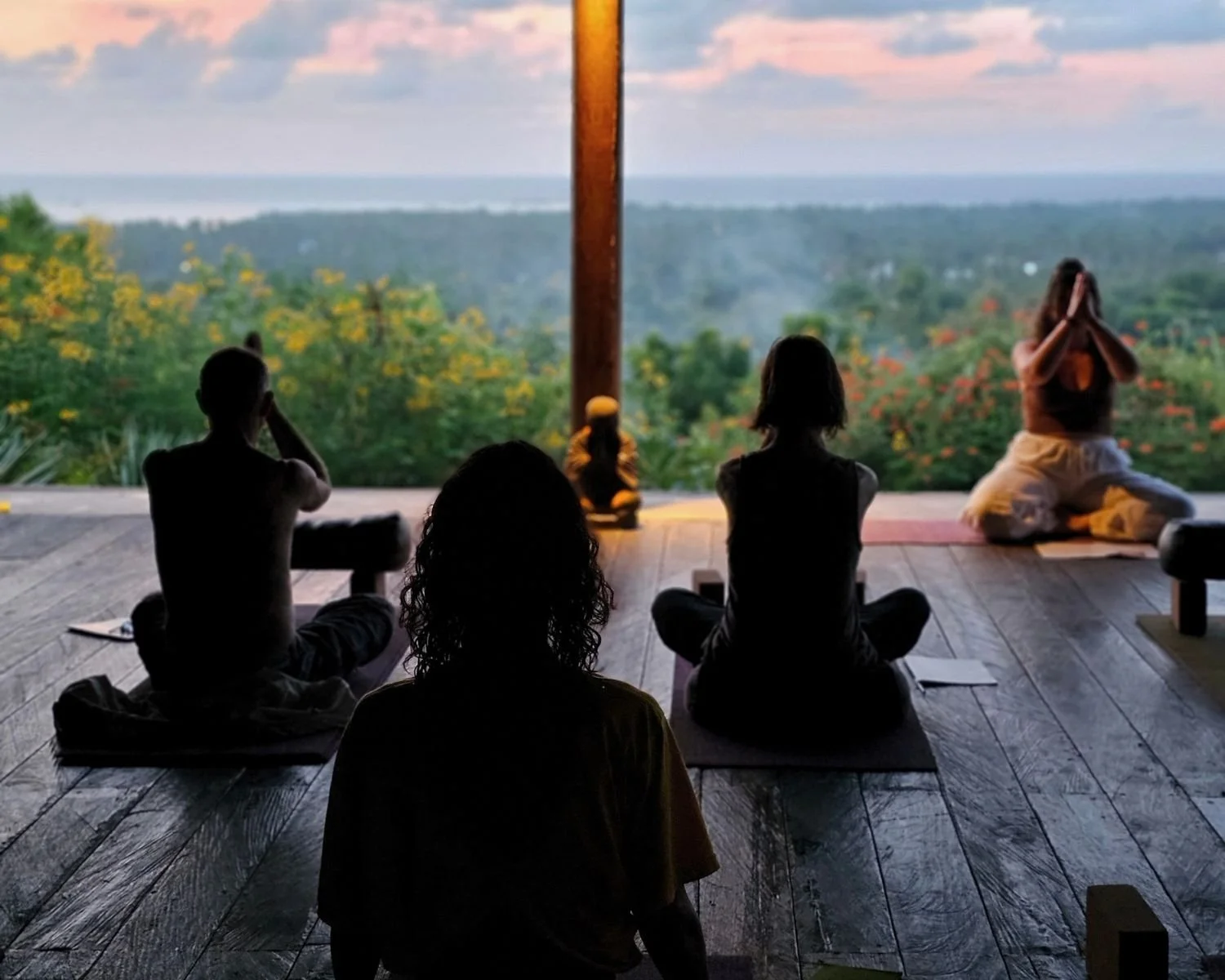 Guests seated in meditation during a sunset yoga practice at the I Am That Studio Bali retreat