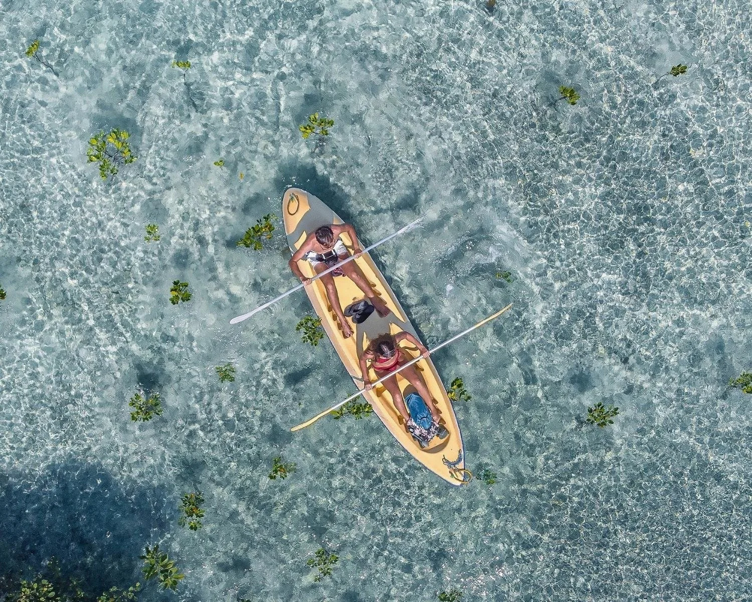 Guests sea kayaking in clear coastal waters at the I Am That Studio Bali retreat in Northwest Bali