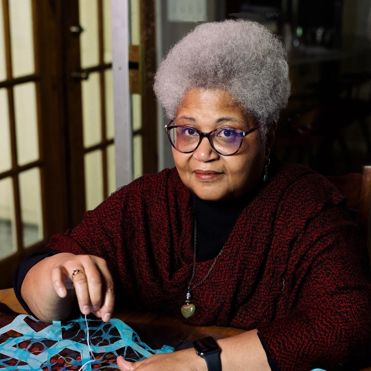 Fiber artist Valerie Goodwin stitching layered textile collage, demonstrating cutwork and mixed media techniques