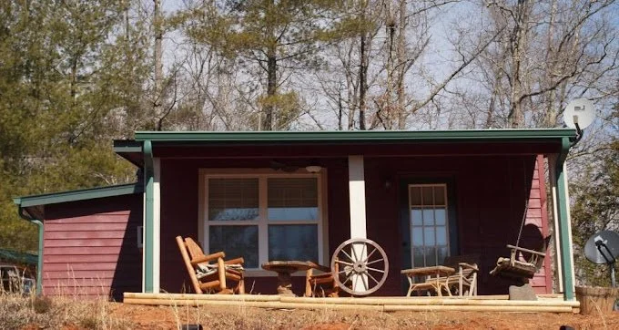 Front porch of Wagonmaster Ranch Resort Cabin, surrounded by trees.