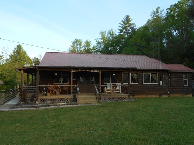 Wagonmaster Ranch Resort Wagon Wheel Event Center with a metal roof and porch, surrounded by green grass and trees.
