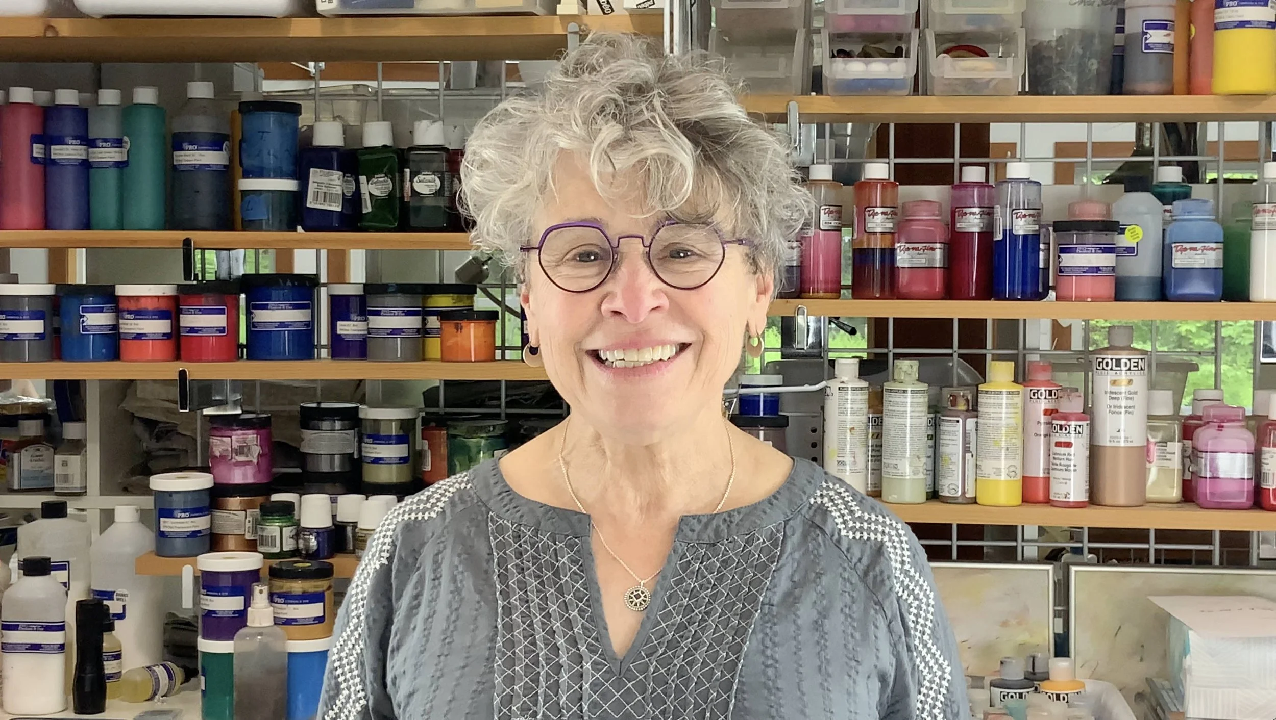 Cheryl Rezendes, surface design instructor, photographed in her studio with textile and paint materials