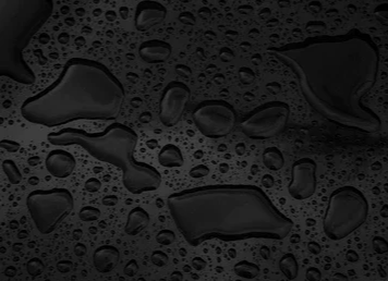 Close-up of water droplets on a dark surface.