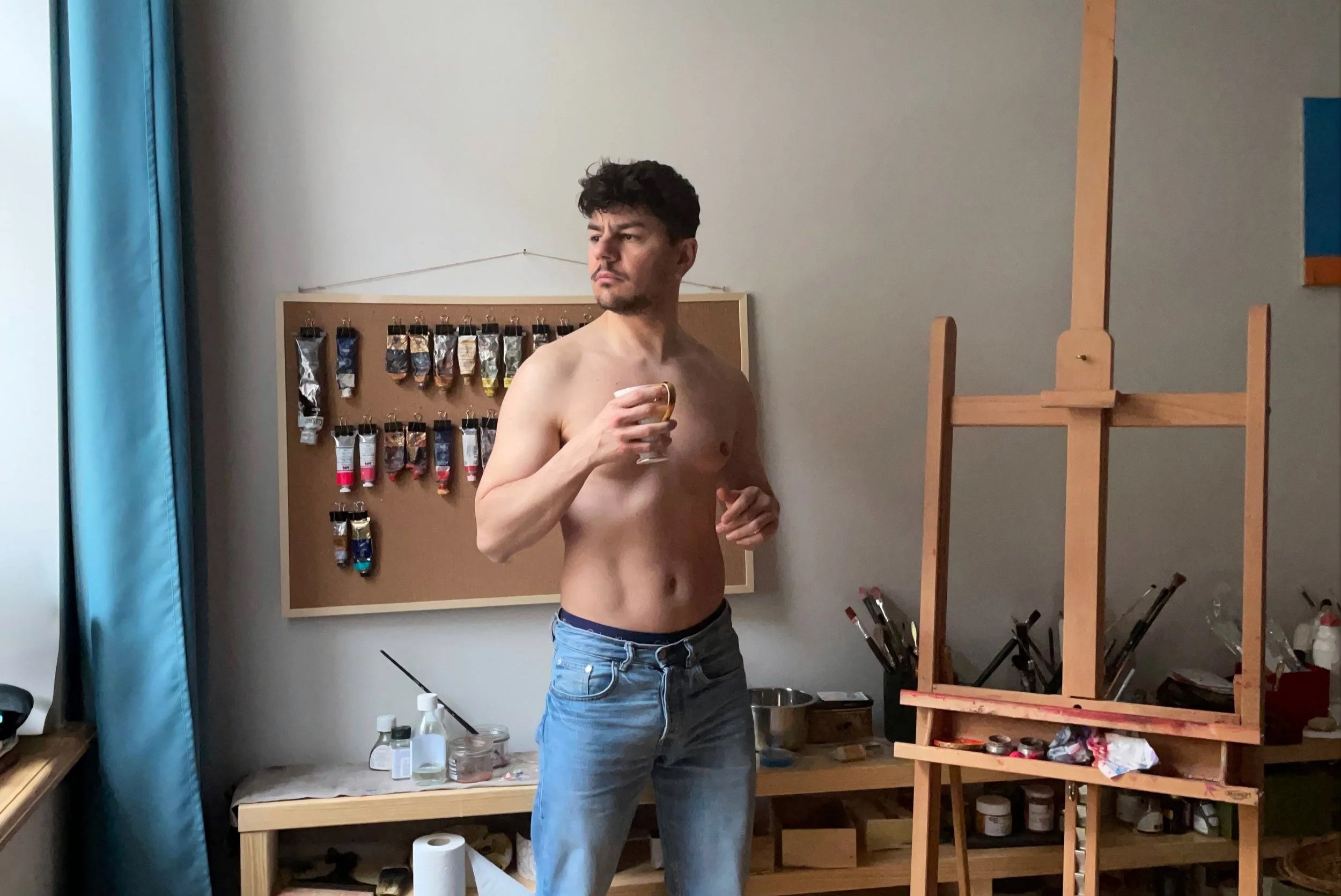 Young contemporary artist Matteo Grillo, standing shirtless in his art studio in Milan.