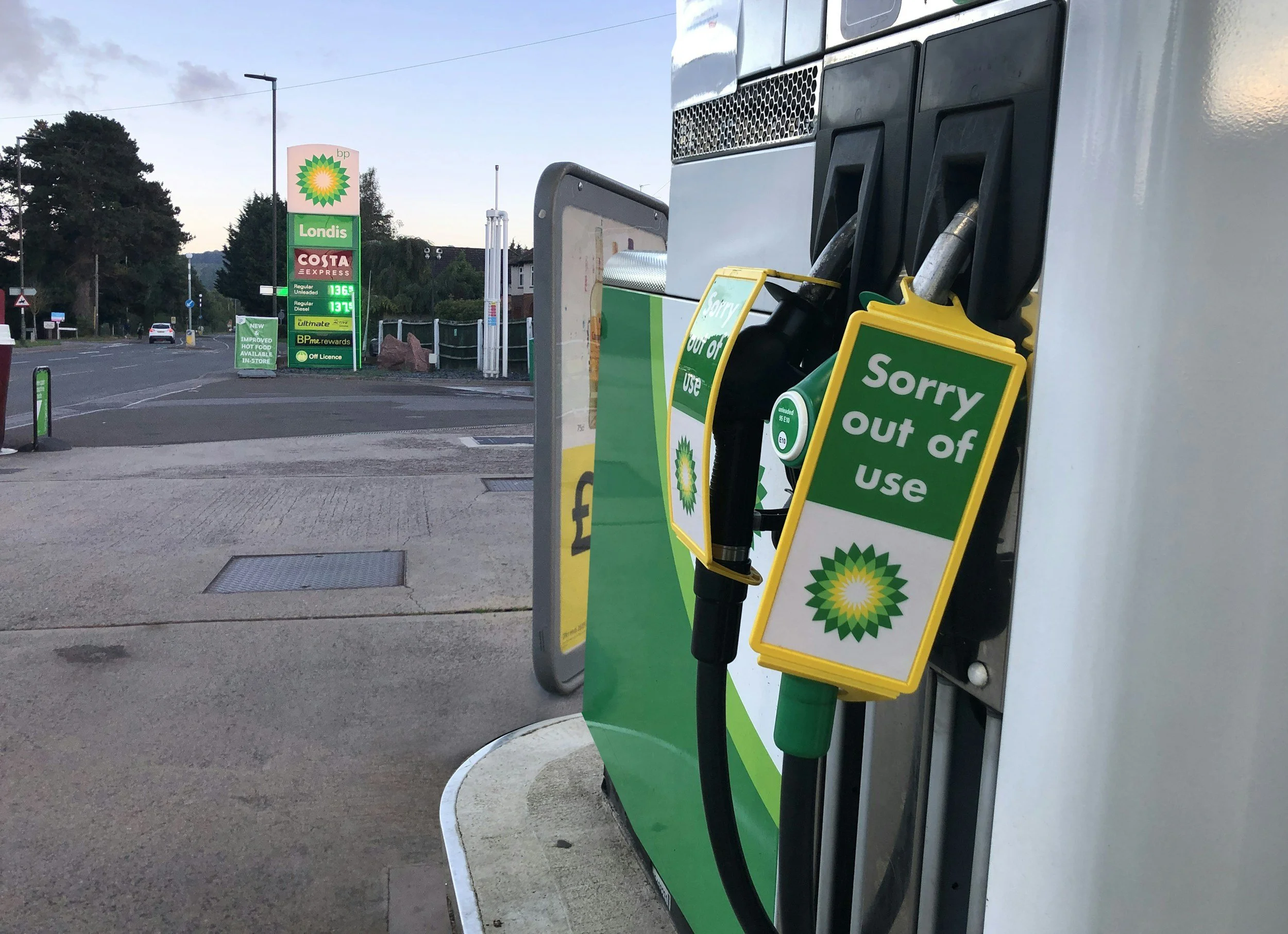 Close-up of petrol pumps at a BP gas station with signs indicating 'Sorry out of use' for some pumps.