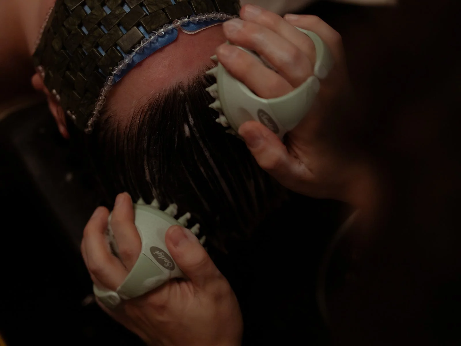 Person wearing a jade eye mask receiving a head spa or scalp massage with a scalp scrubber that helps with oily or dry scalp. Also for thinning or damaged hair.