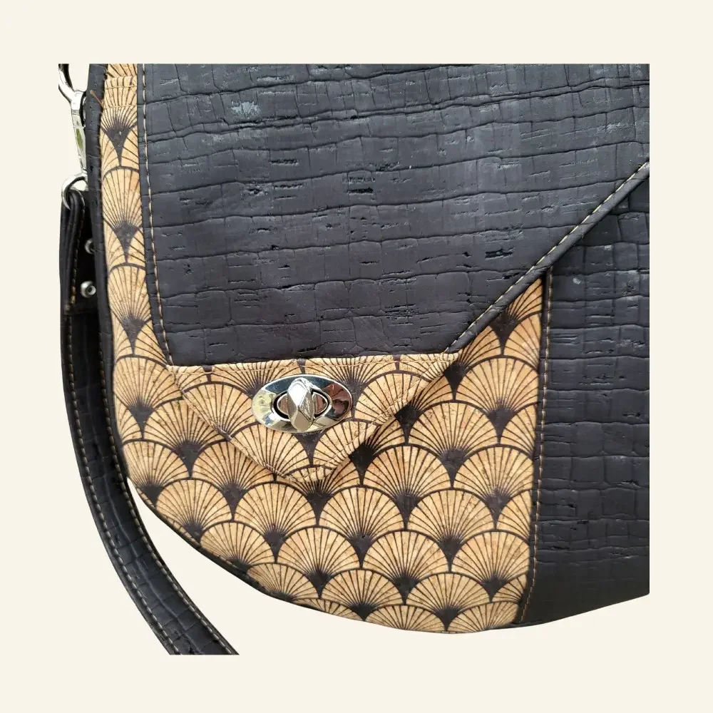 Handgemaakte schoudertas zwart kurk met waaiermotief detail sluiting.webp