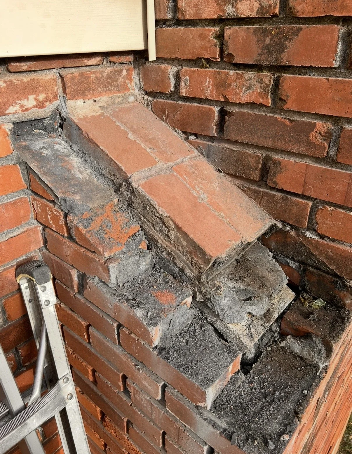 Before picture of a brick chimney with shoulder damage allowing water inside the home.