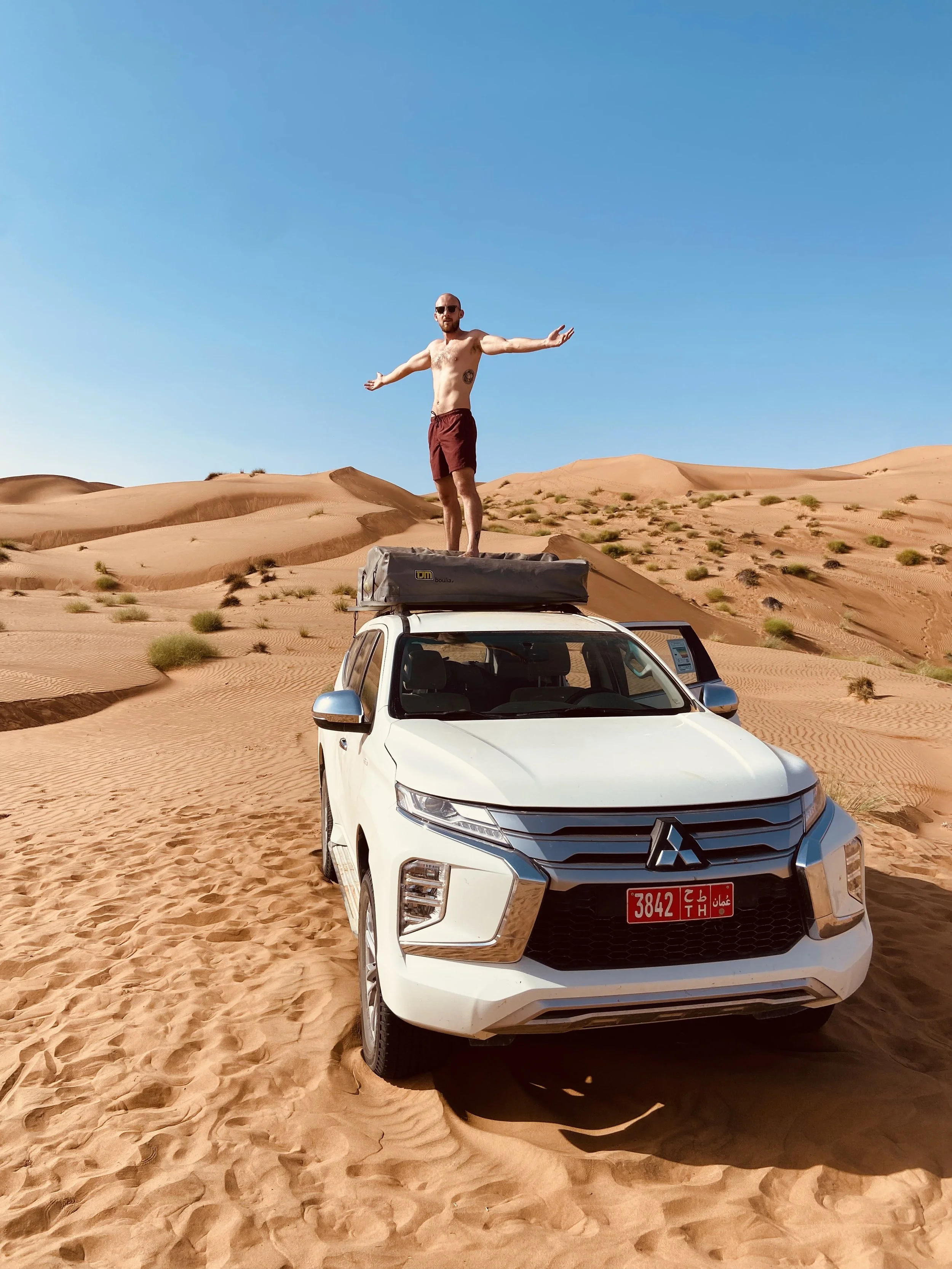 A man on a 4x4 car in the middle of the desert