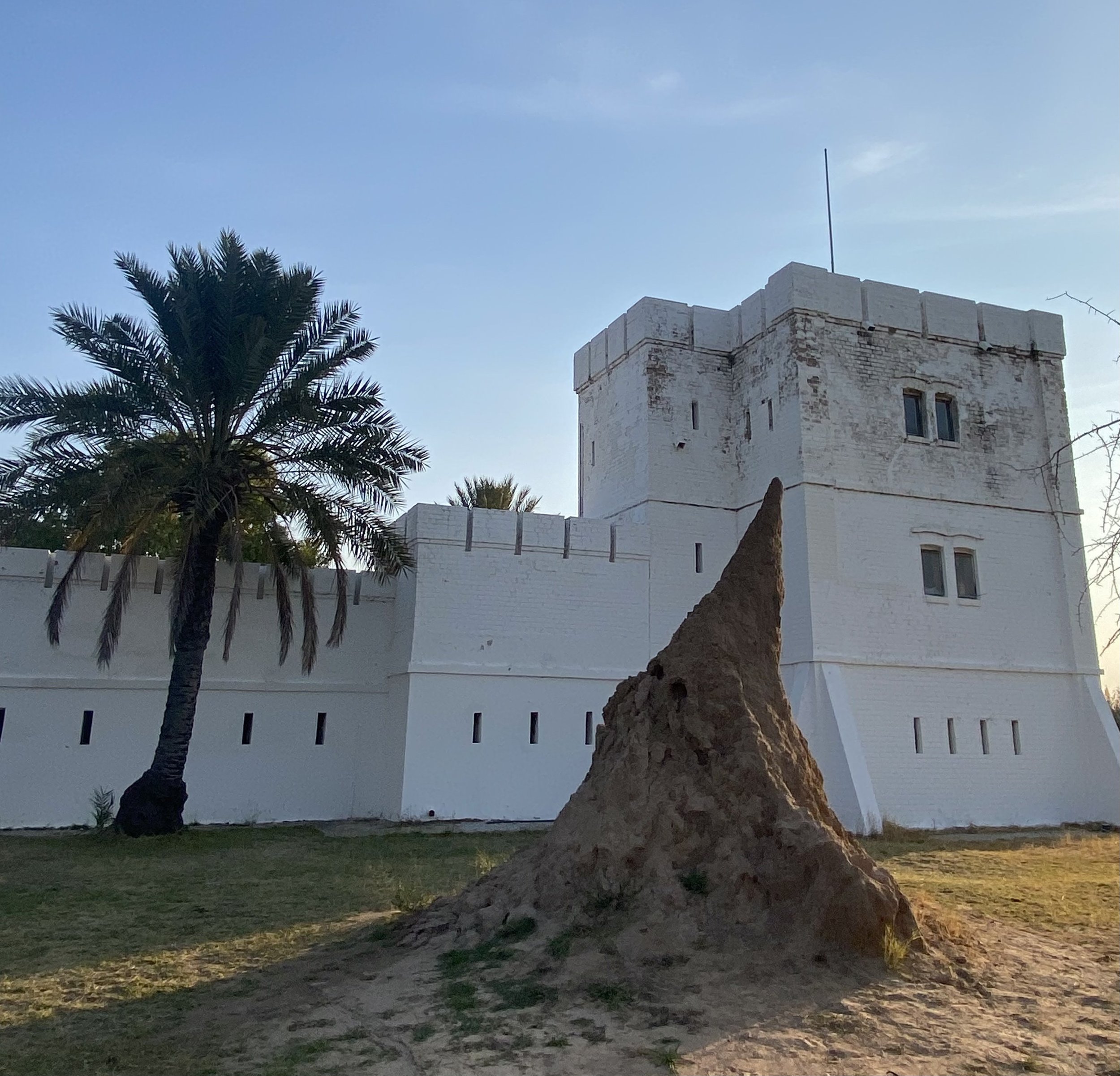 The historic white walls of Fort Namutoni near Omuthiya and eastern Etosha National Park beside a large termite mound.