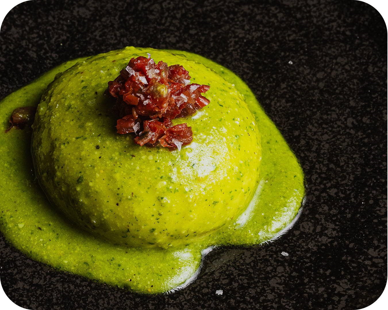 Cilindro de postre con salsa verde y topping de carne seca.