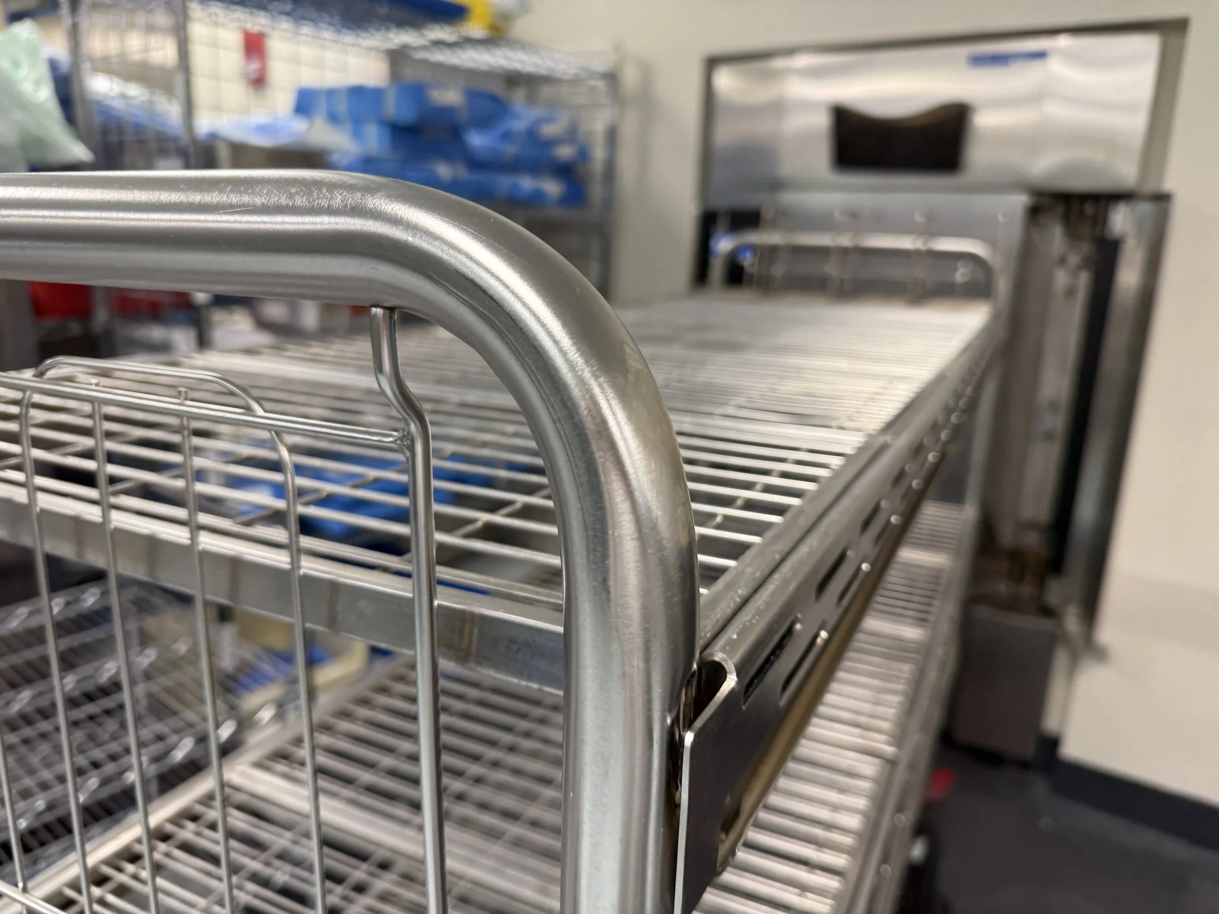 Close-up of a stainless steel wire shelving unit in a surgical setting.