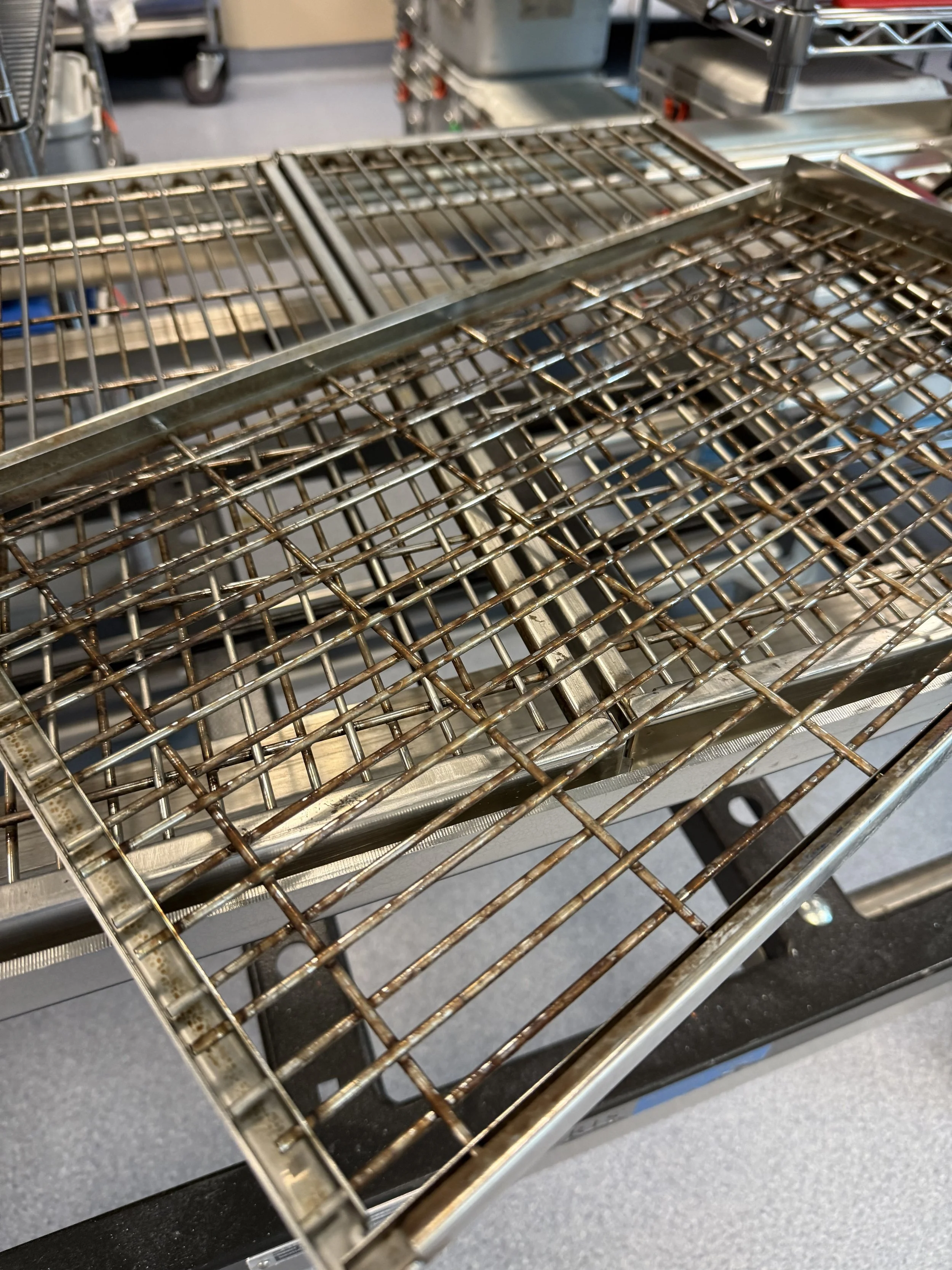 A set of racks that has heavy bioburden buildup and adhesvies.