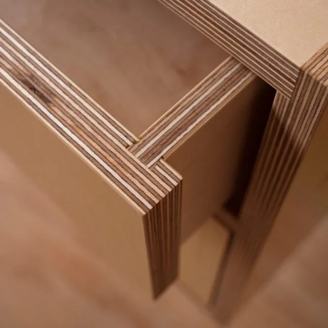 Close-up of layered wooden plywood pieces assembled into a corner structure.