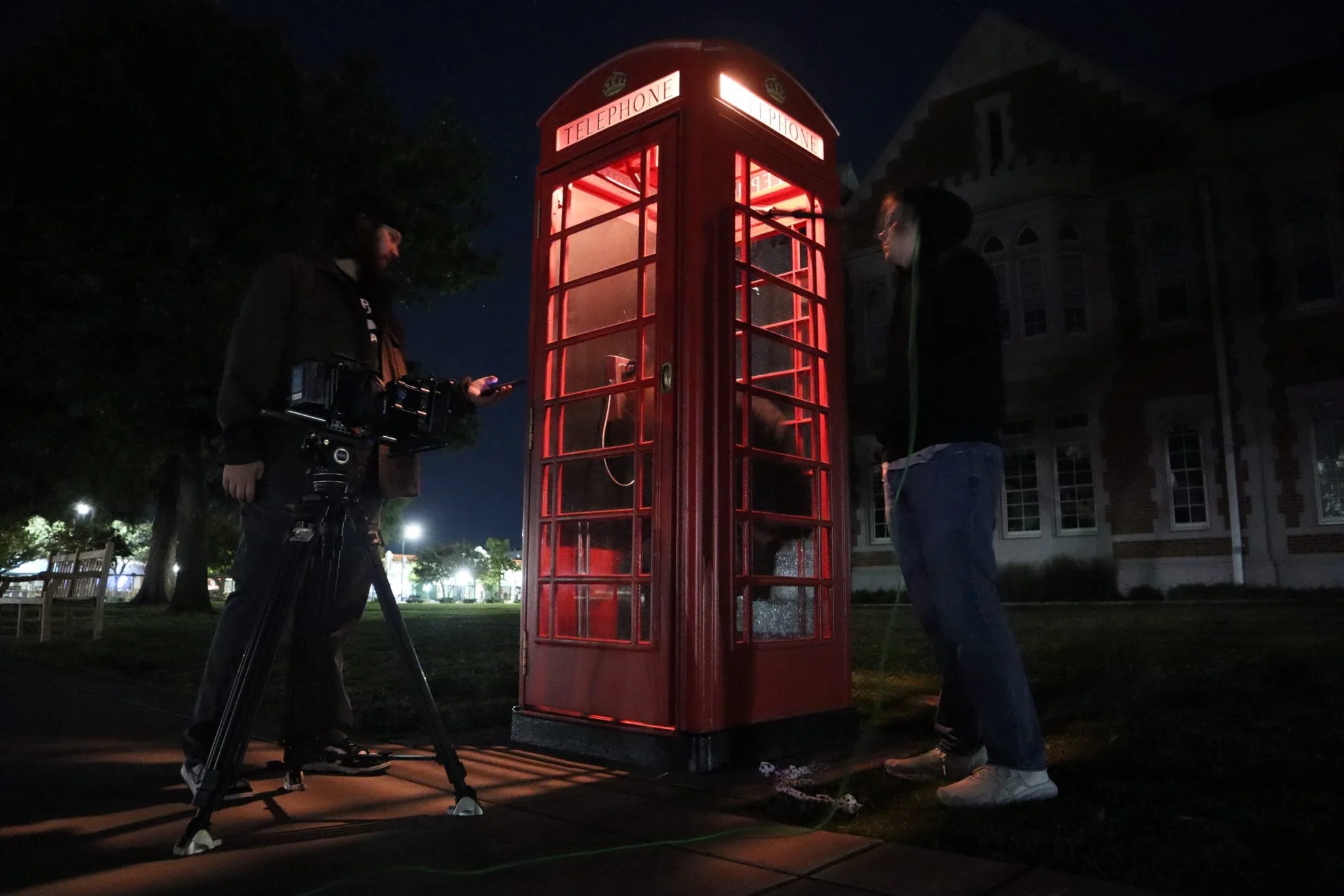 People filming around a red British telephone booth at night. BTS from the short film CALL GIRL (2026).
