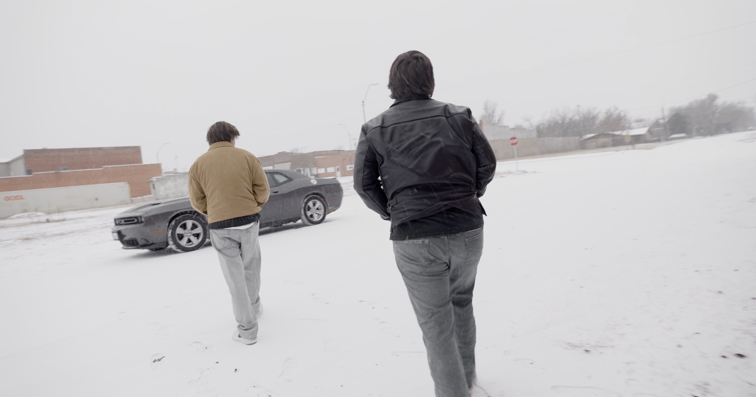 Ryan Christopher Park & Jake Ayers walking through the snow to their car, a still from the short film HOTHEADS (2025).