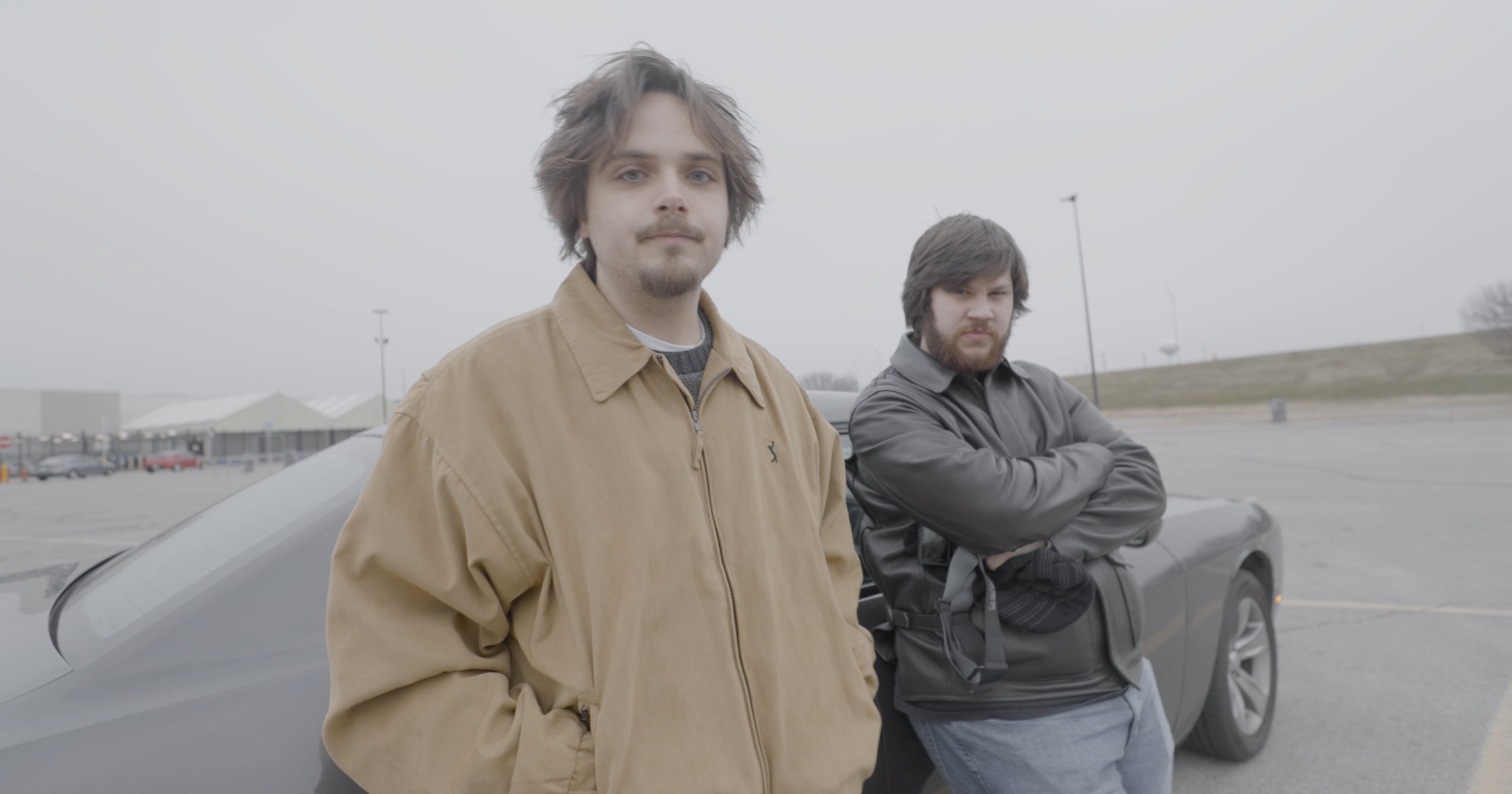 Ryan Christopher Park and Jake Ayers in a still from the short film, HOTHEADS (2025), standing in a Walmart parking lot.