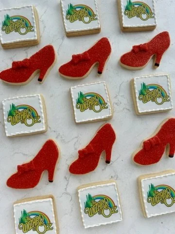 Cookies decorated with red high heels and 'Wizard Oz' logo.