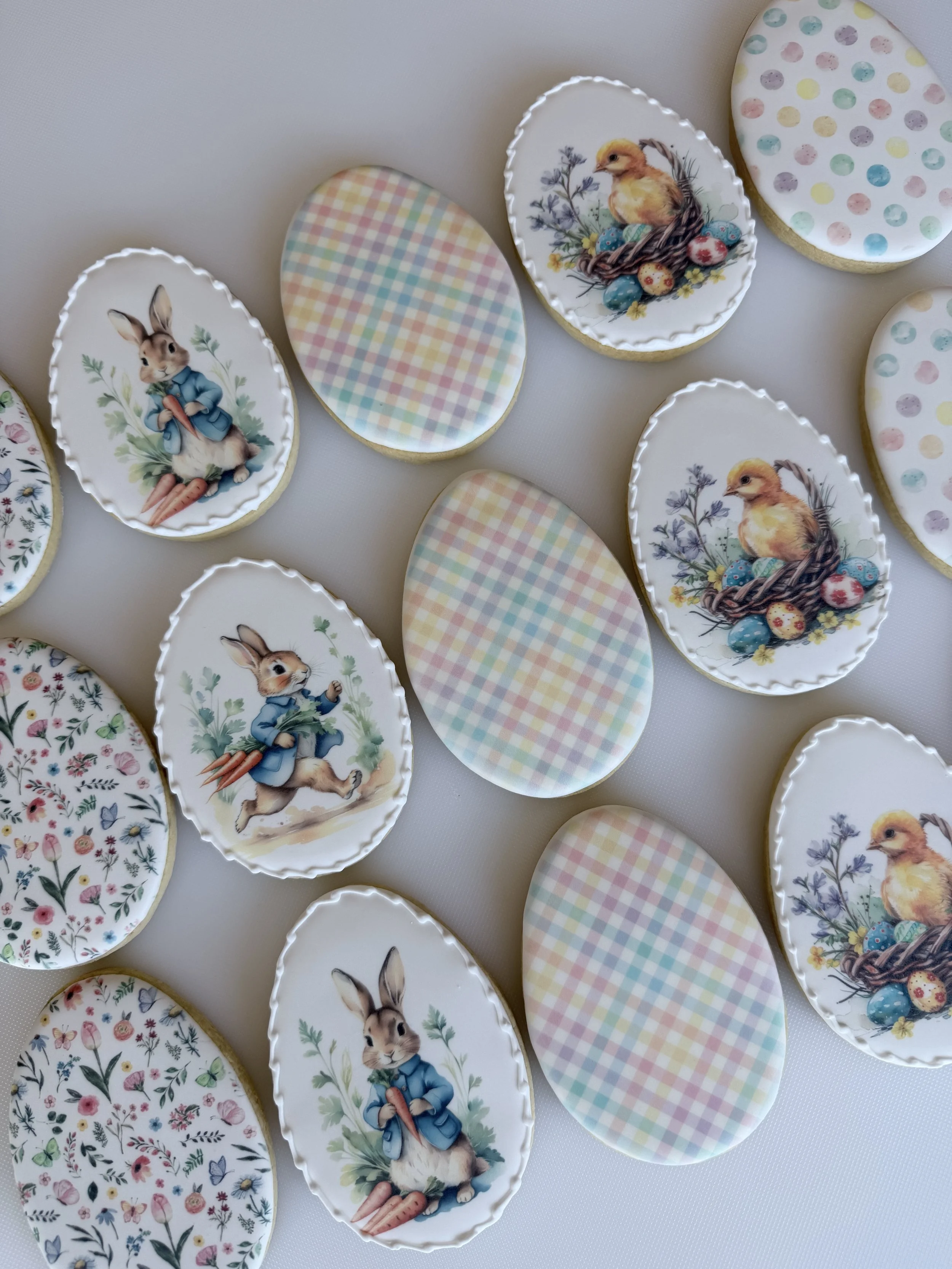 Assorted decorated Easter cookies with bunny and chick designs, and pastel-colored gingham patterns.