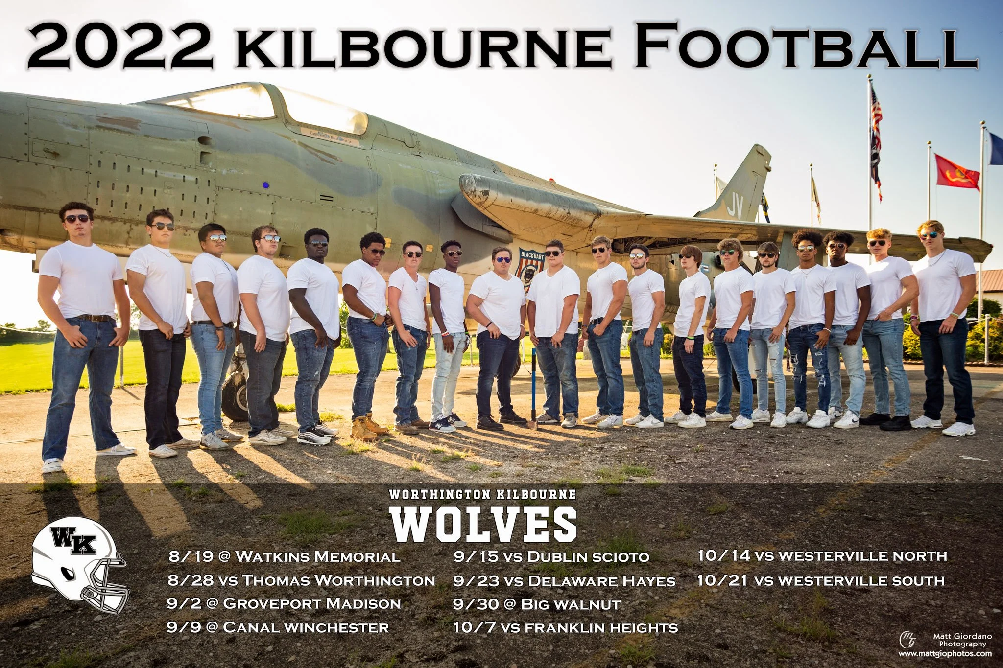 Group of young men standing in front of a military aircraft with flags in the background, wearing white t-shirts and jeans, promoting Worthington Kilbourne Wolves football season for 2022.