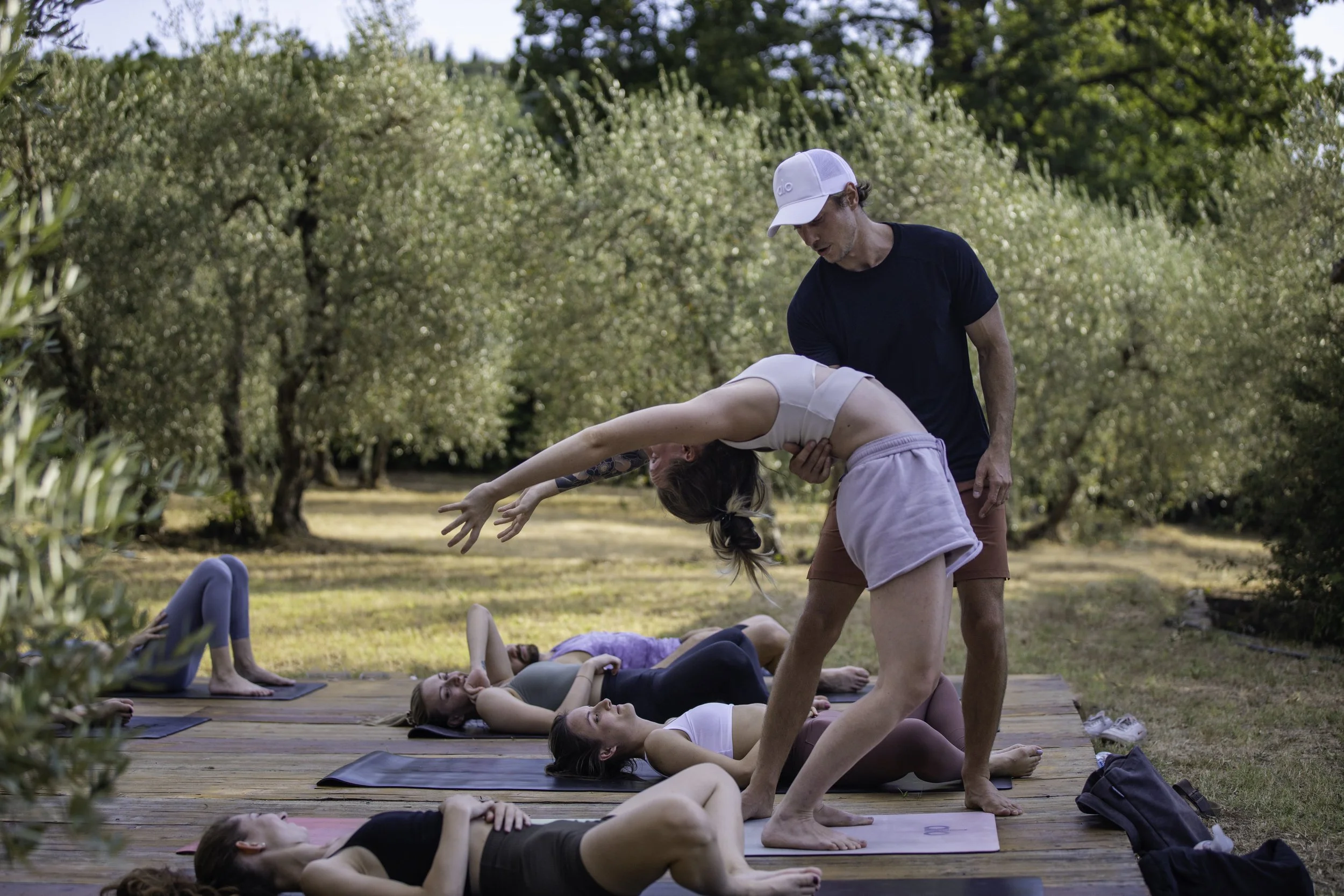 A Yoga Class outdoors with assist and adjustment
