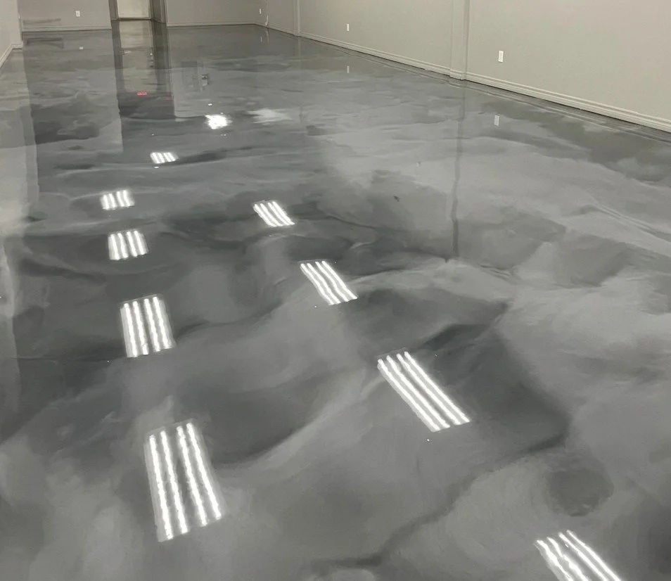 Suelo de piso de concreto con acabado pulido, reflejando las luces del techo.