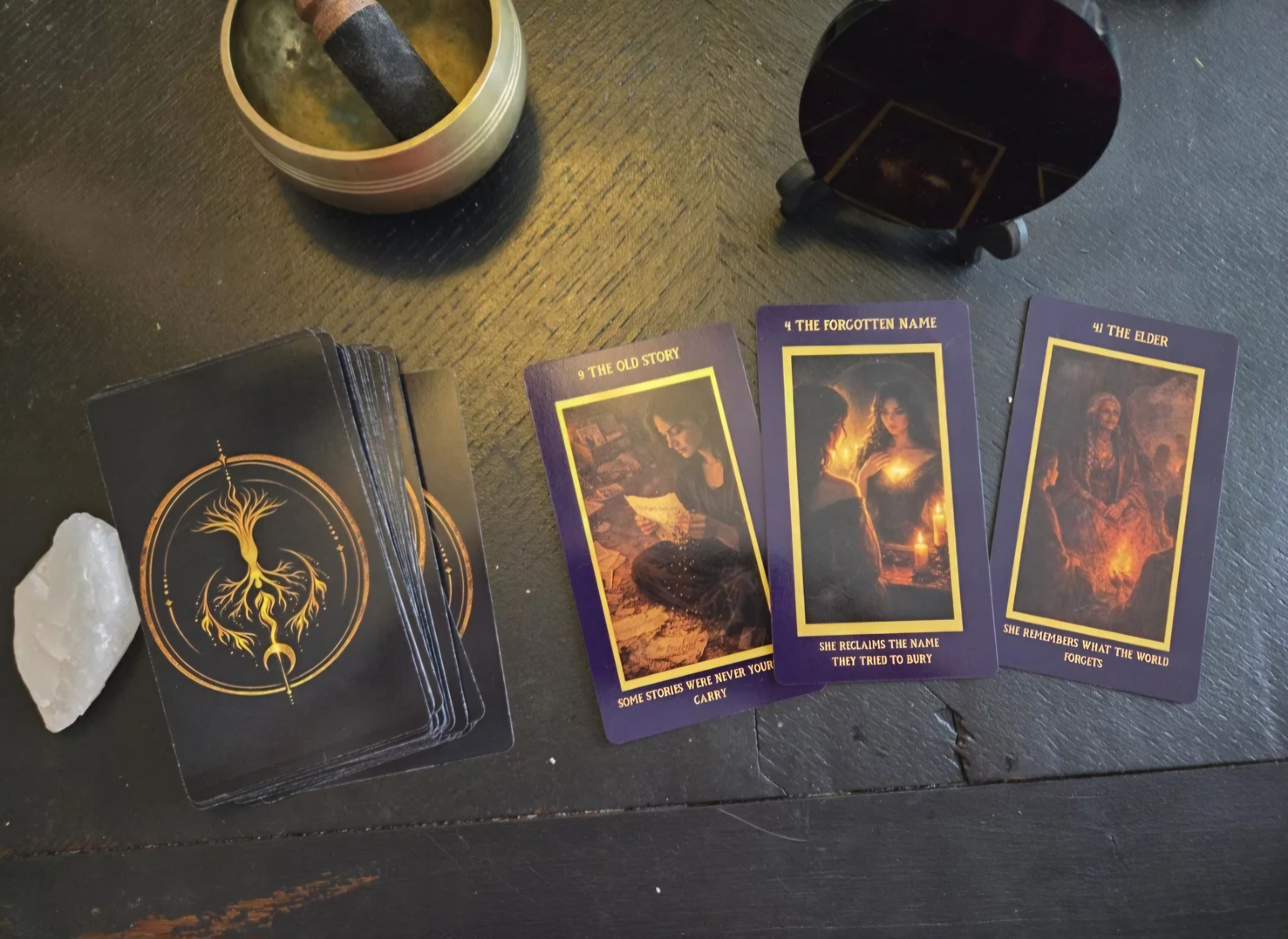 Dangerous Woman Oracle cards spread on a black desk with crystal – The Old Story, The Forgotten Name, The Elder