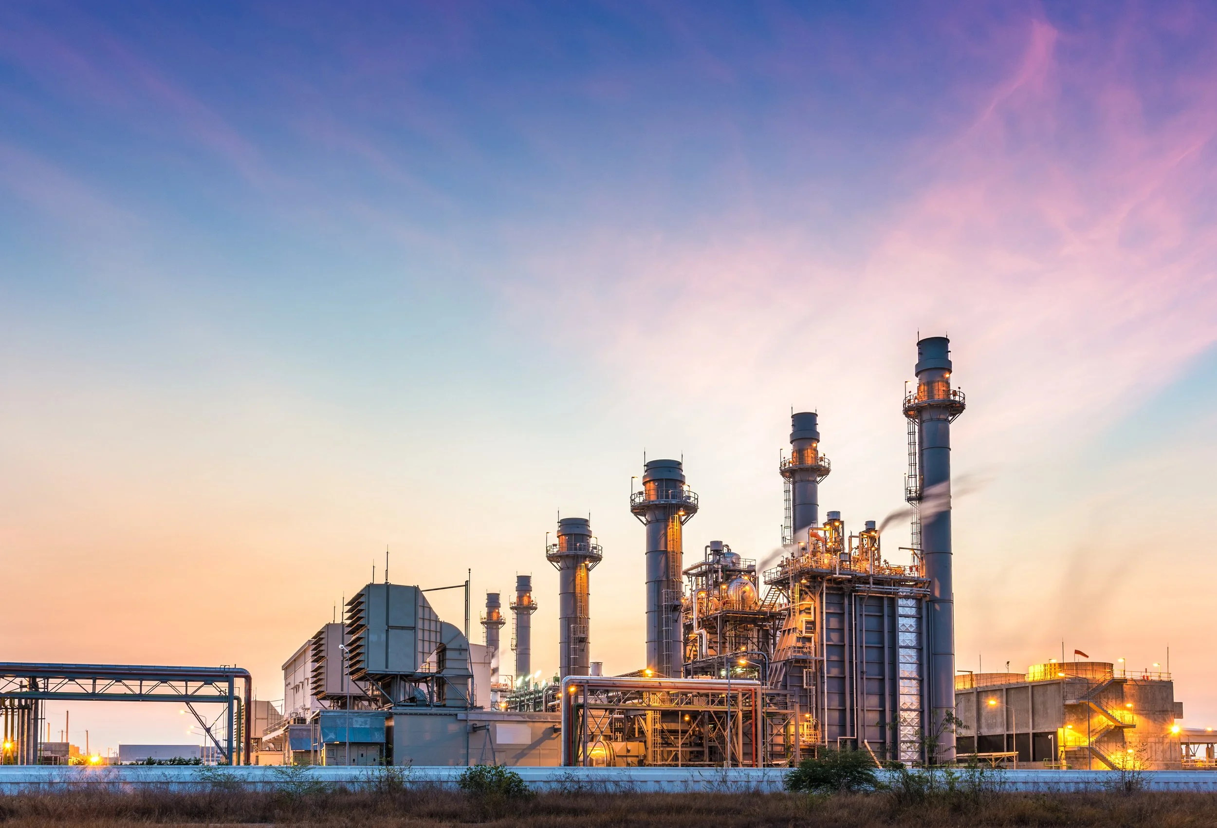 Combined-cycle power plant smokestacks at sunset