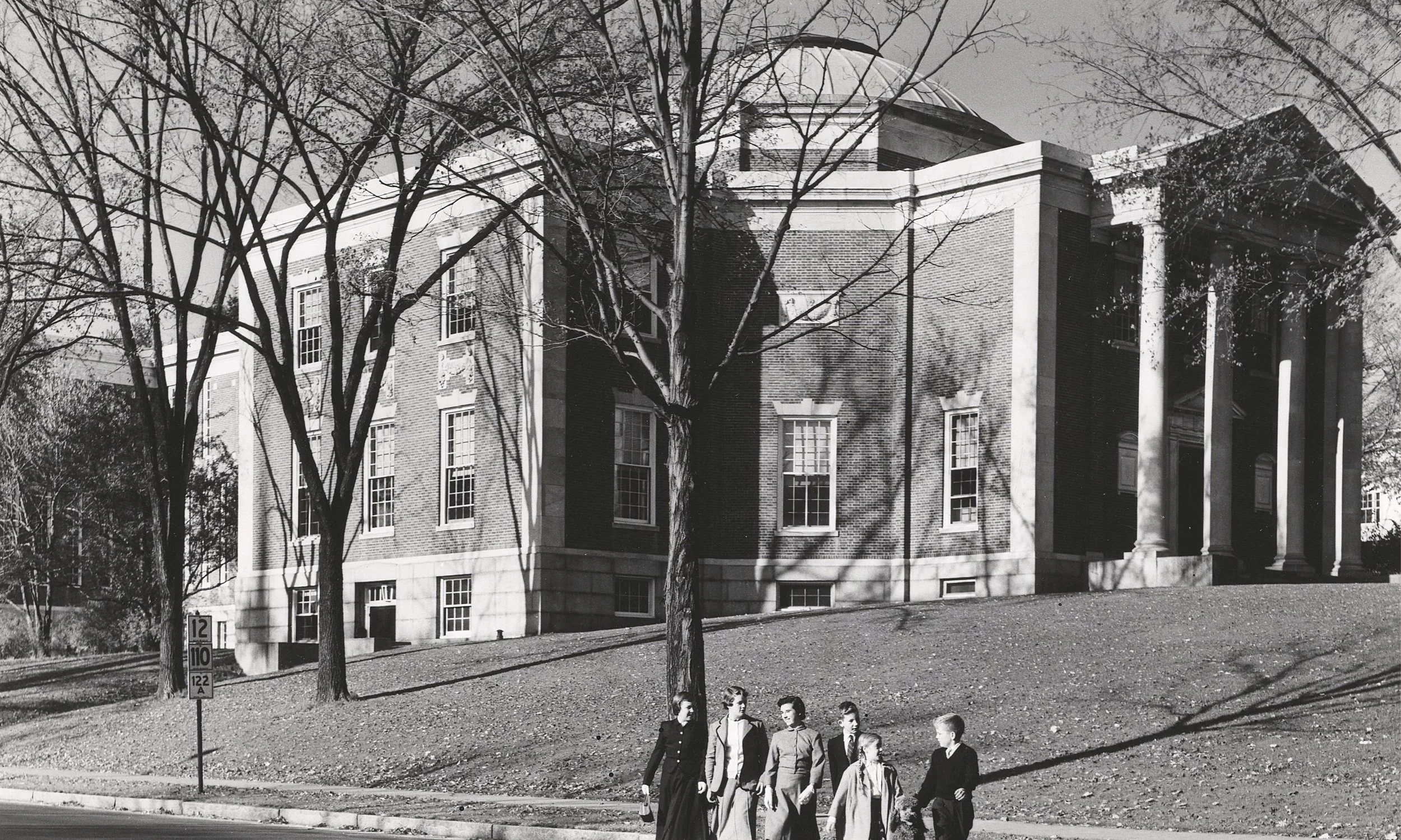 Black and white photo of students walking in front of a the American Antiquarian Society, Worcester, Massachusetts.