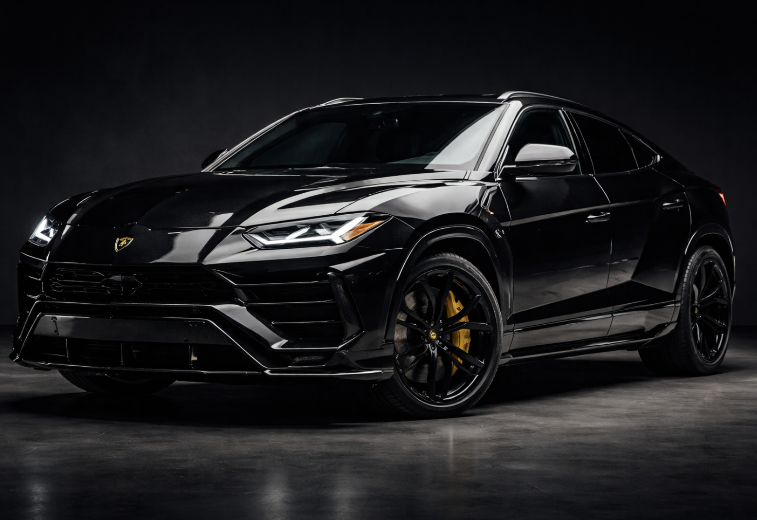 Black Lamborghini SUV on a dark studio background with reflections on its shiny surface.