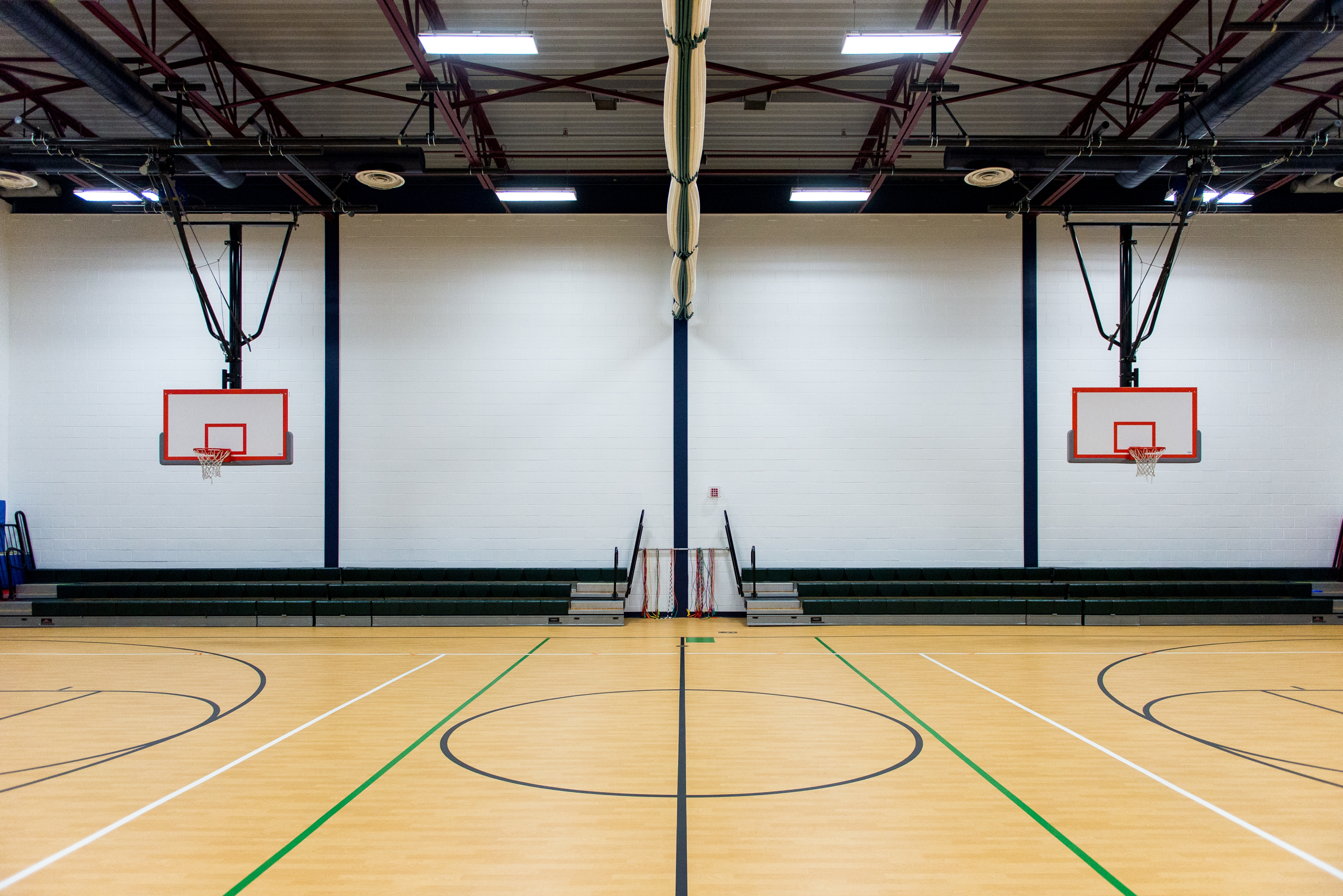 Empty indoor basketball court with a hardwood floor.