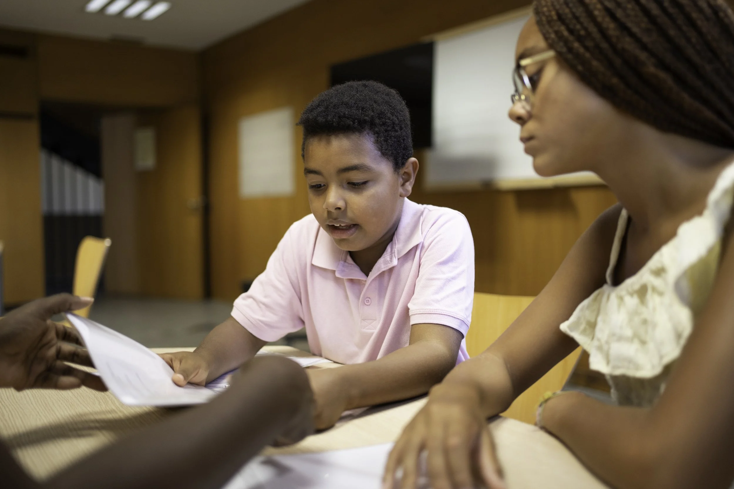 A student and an adult reviewing documents together in a classroom.