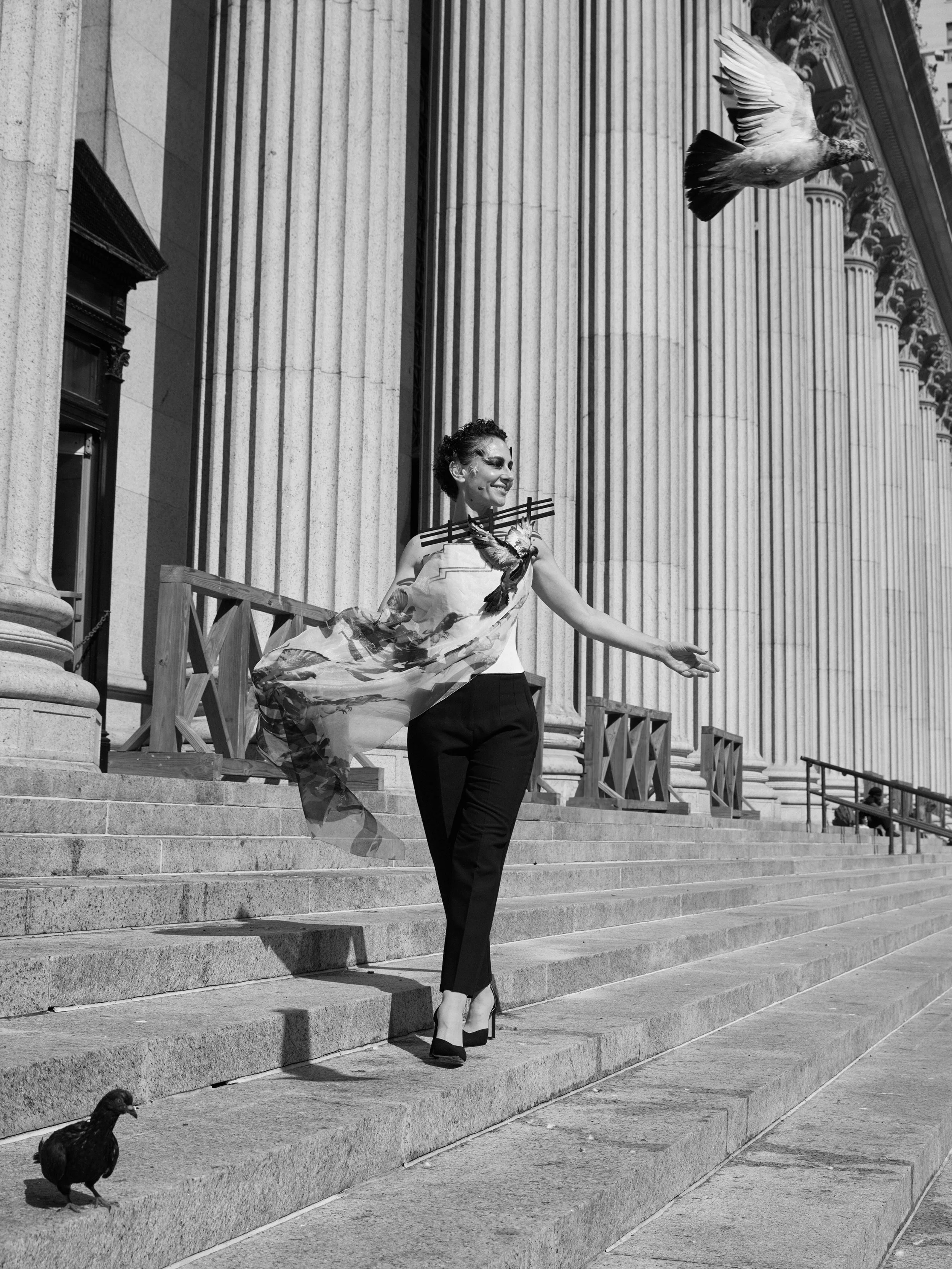 Nicky Conti in the Adaptress look walking on the James A Farley Post Office stairs as pigeons move around her, featuring a boned corset and organza layer printed with a flock of birds