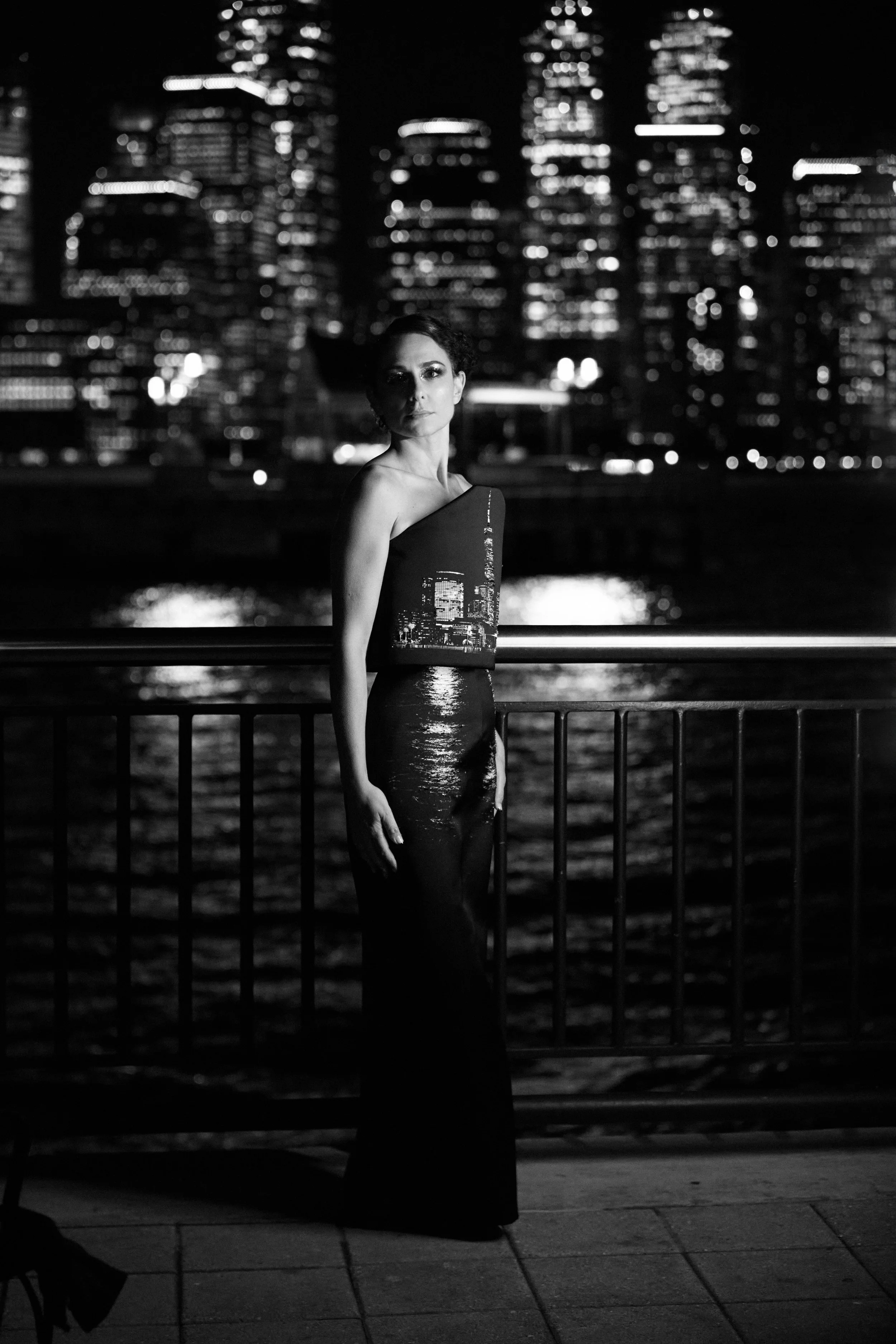 Nicky Conti in the Dazziliance custom look featuring a skyline print across the structured bodice and water reflections on the skirt, with hand-beaded details emphasizing light from the city