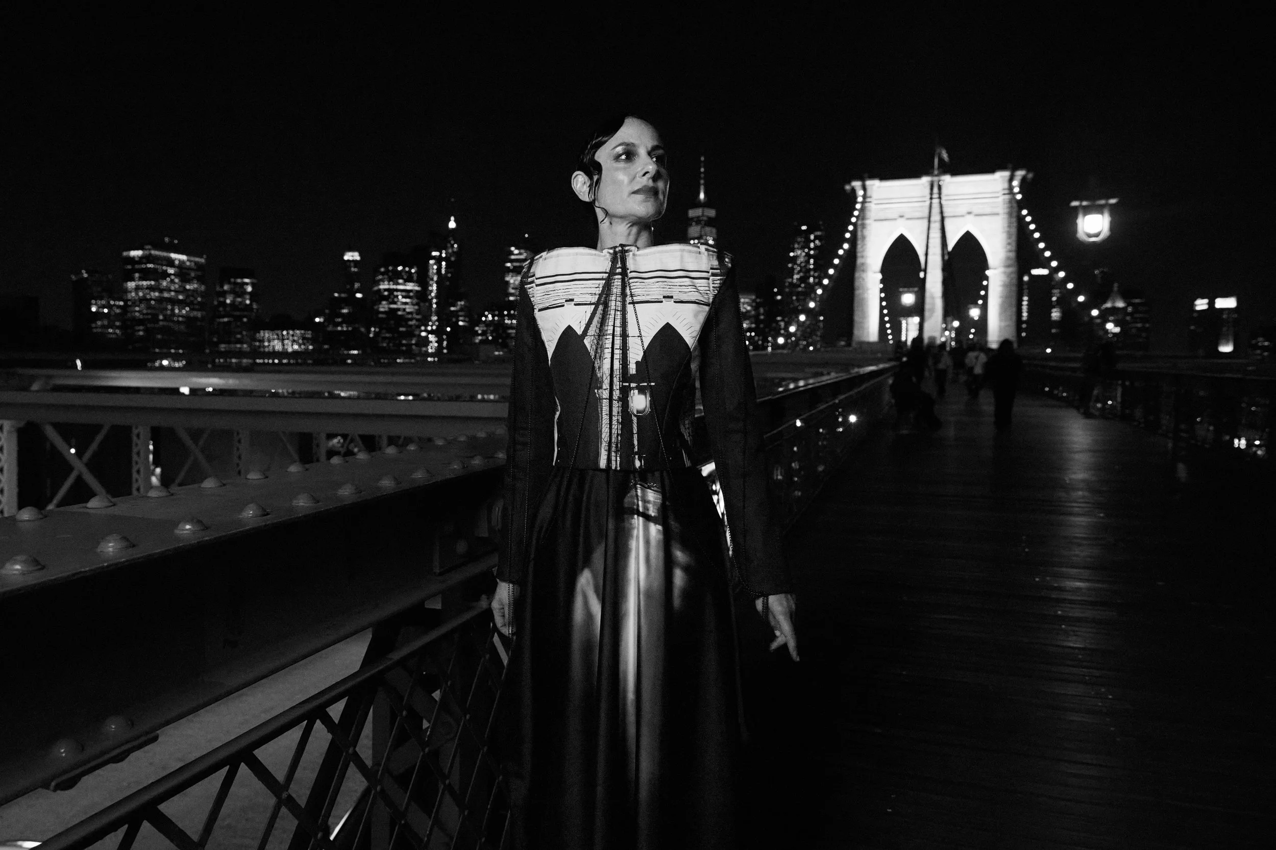 Nicky Conti wearing an architectural couture look inspired by the Brooklyn Bridge and Emily Warren Roebling, photographed on location at night in New York City