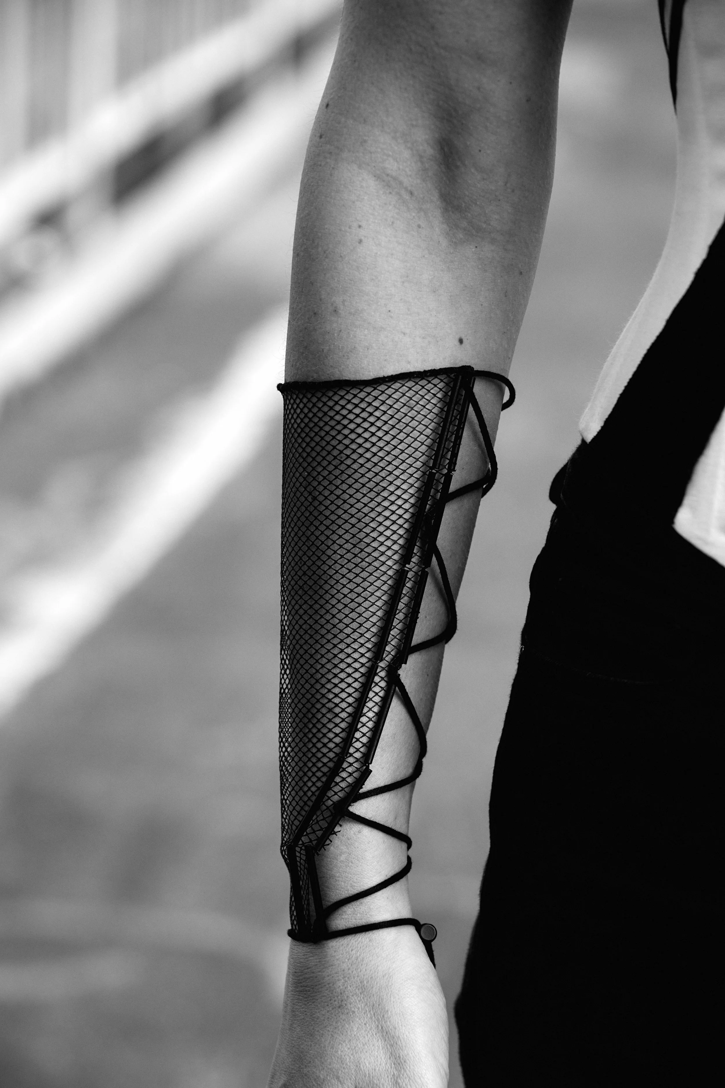 Nicky Conti wearing the Ironick piece, close-up of a sleeve constructed with mesh and boning, tied with black piping ribbon