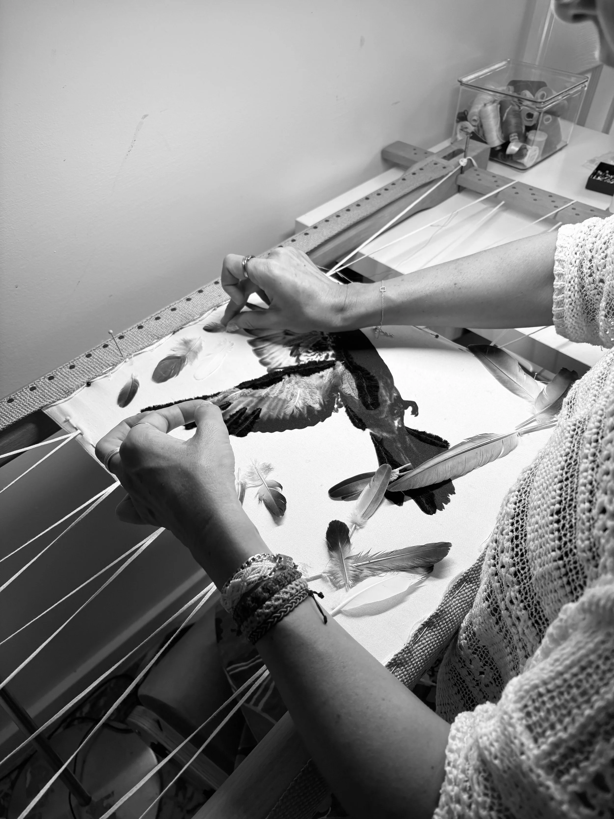 Sarah Esmoingt embroidering real feathers onto a printed pigeon image on cotton canvas for the Adaptress garment