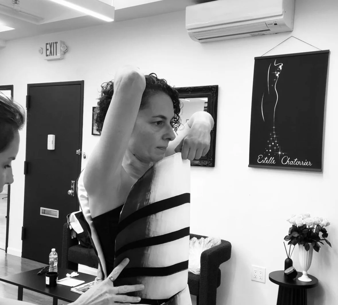 Nicky Conti during a fitting, wearing a partially constructed couture garment as adjustments are made to the structure and silhouette