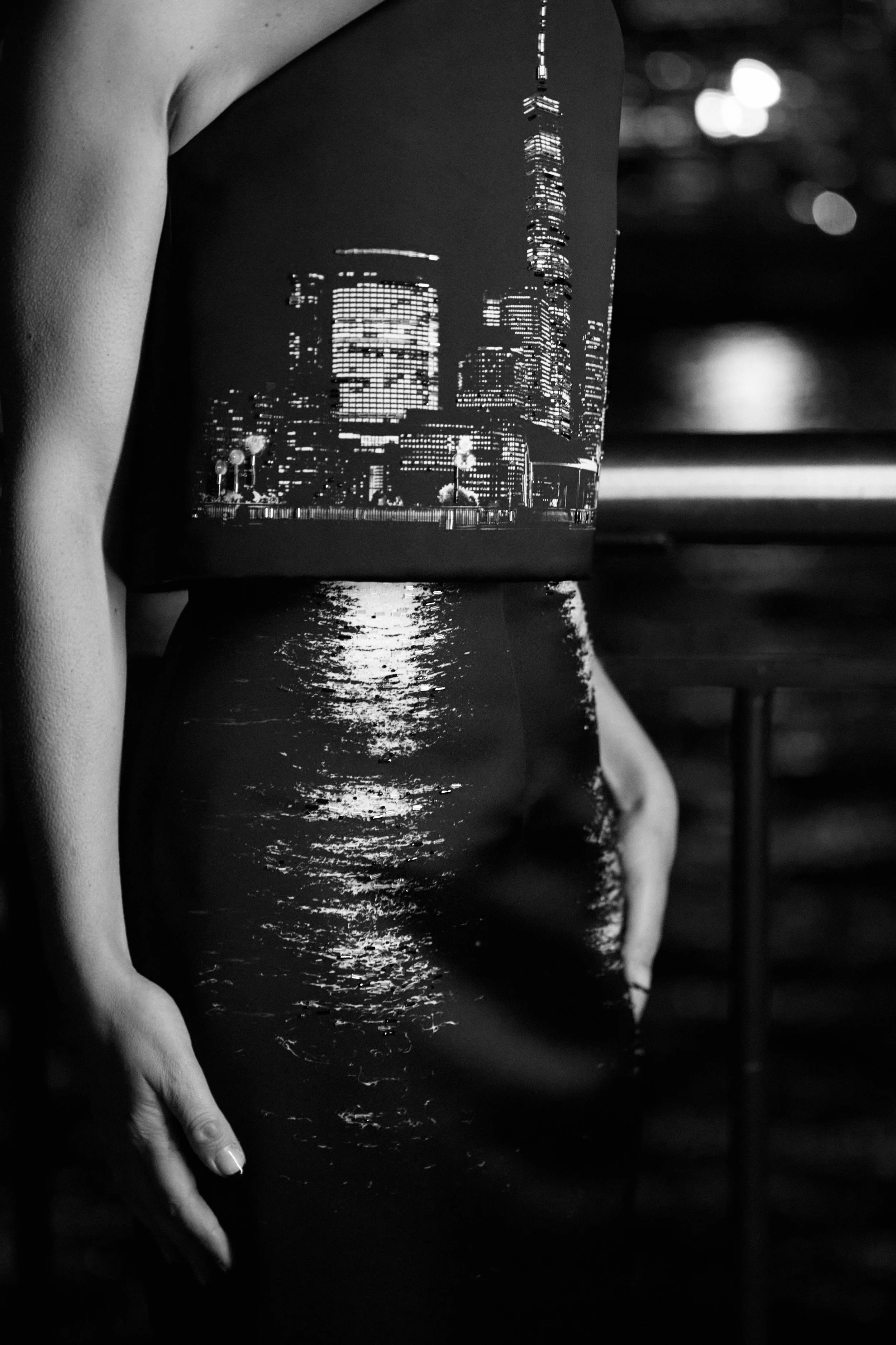 Nicky Conti in the Dazziliance two piece couture made from a printed photograph of the NYC skyline and river, with bead embroidery highlighting the building lights and their reflections on the skirt
