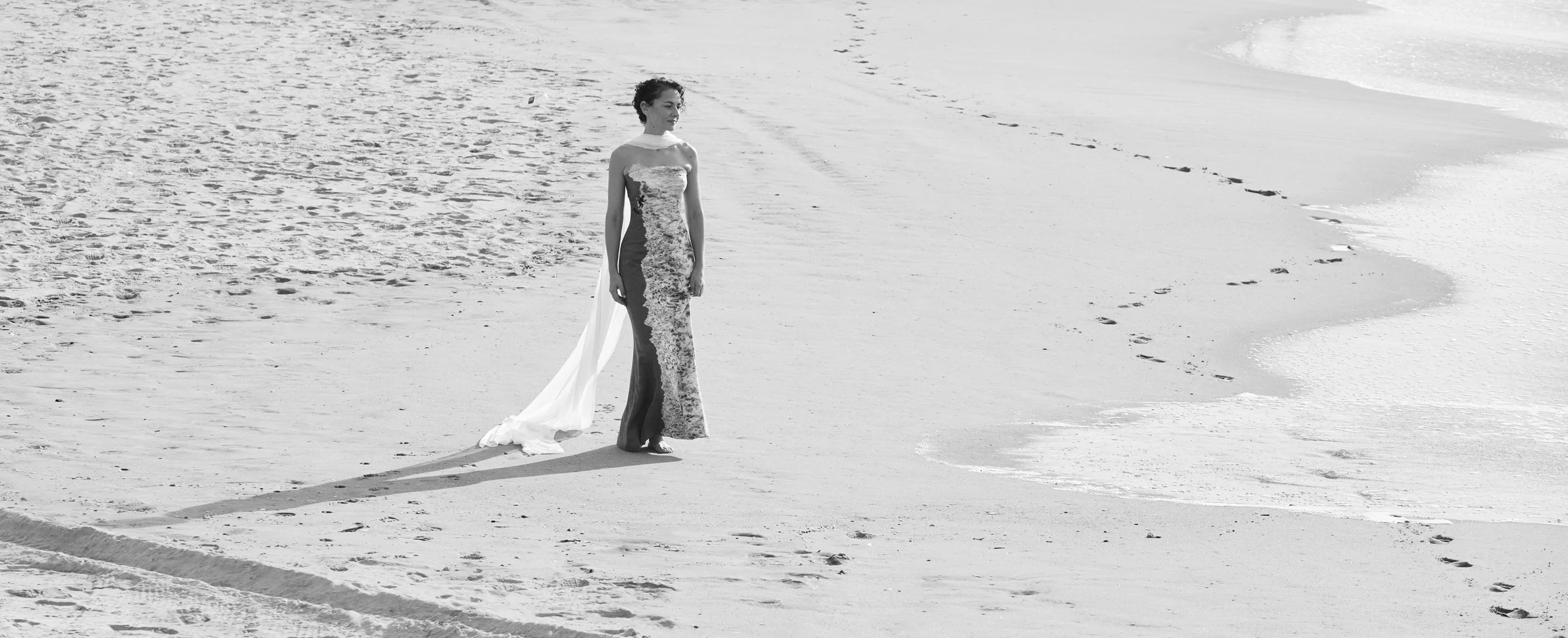 Distant view of Nicky Conti walking along the shoreline at Coney Island Beach, photographed from the pier where the original image was captured