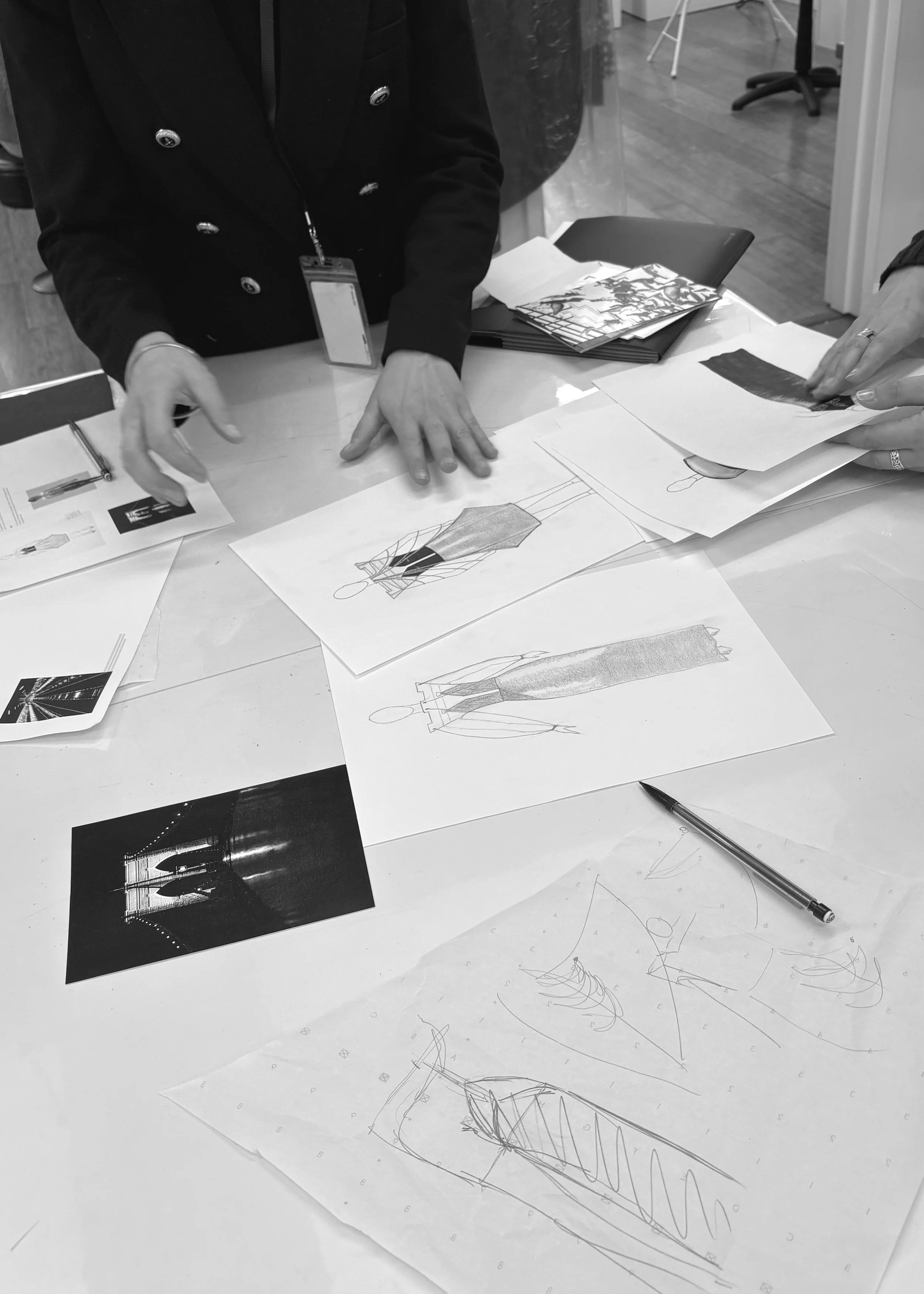 The team reviewing sketches and the photo during a meeting a the atelier in the Garment District, New York City
