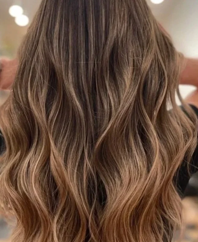 Close-up of long, wavy, light brown hair with highlights.