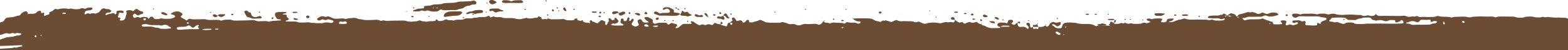 Close-up of a brown paintbrush stroke on a black background.