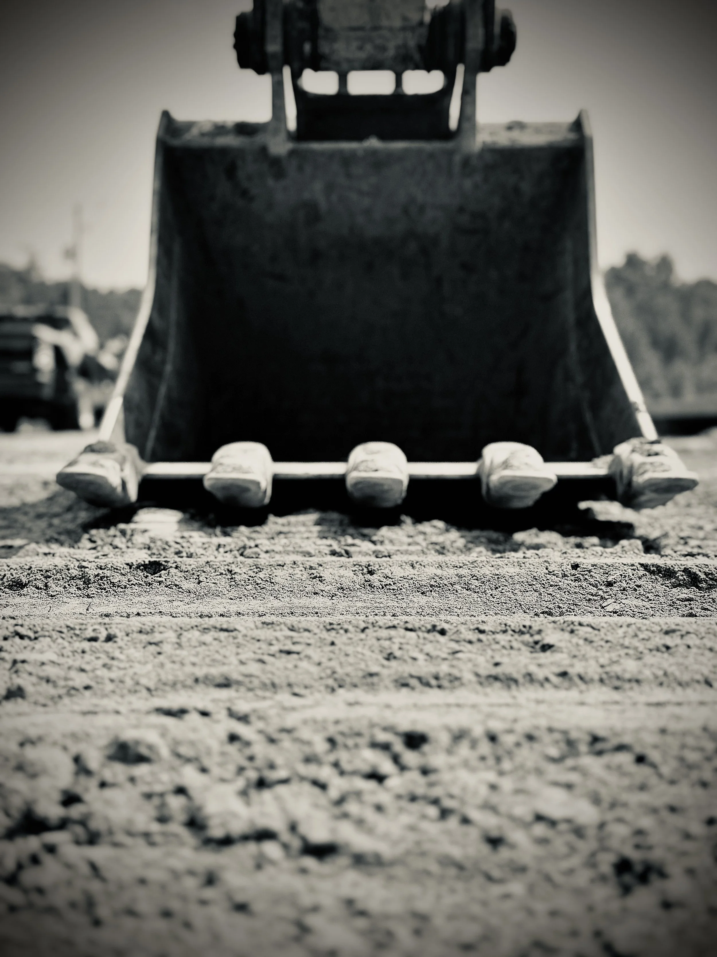 Close-up of a toy dump truck on a dirt surface, with a blurred background