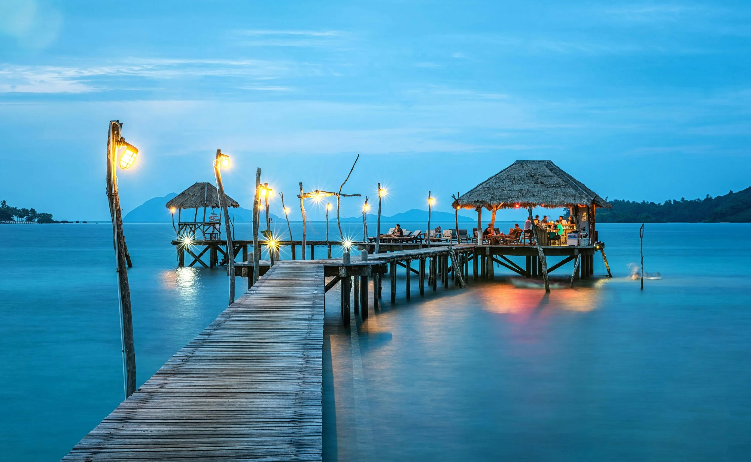 Overwater dining at dusk — Miller Travel Group curates premium travel experiences for discerning travelers