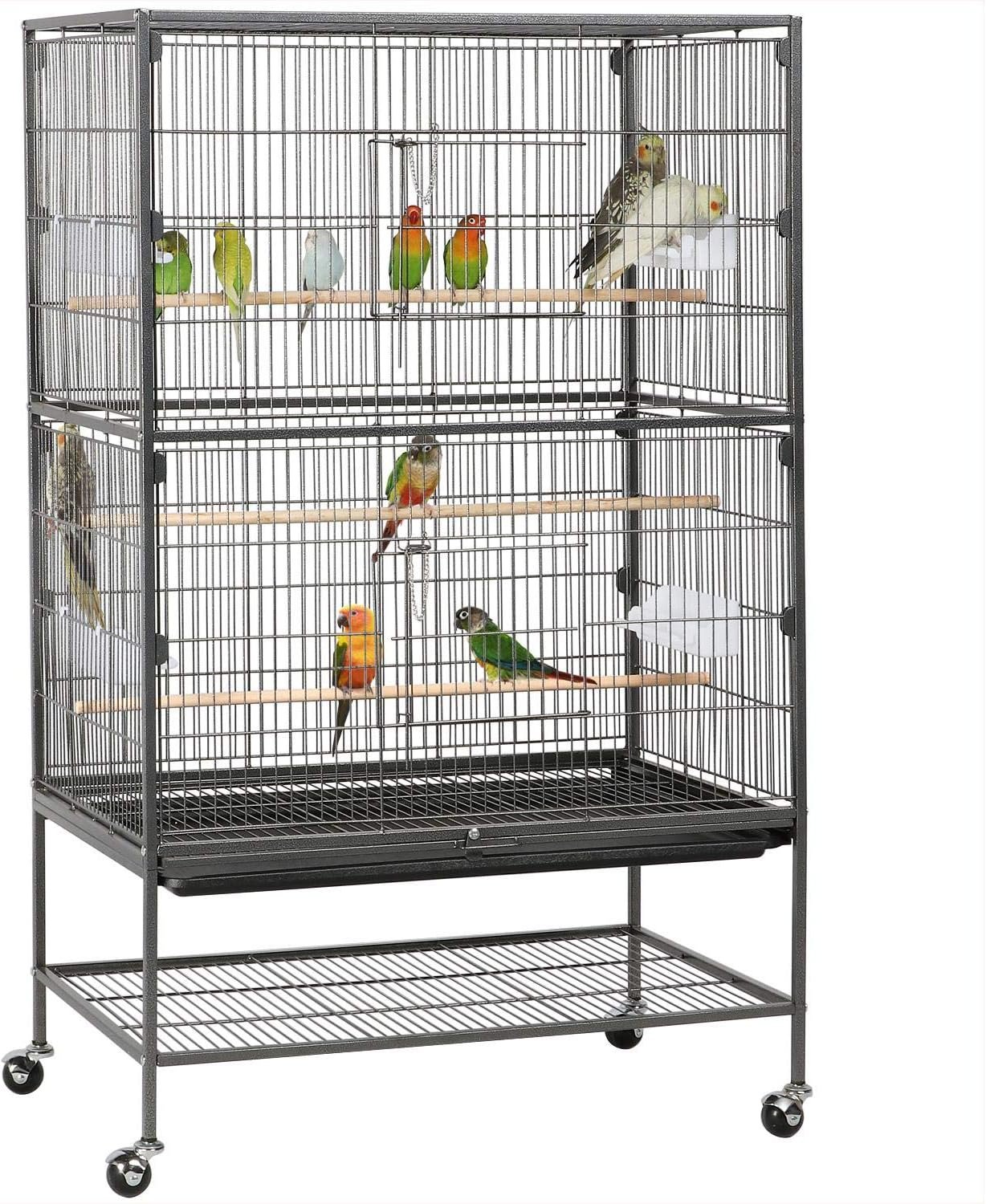 A large metal birdcage on wheels containing multiple colorful parrots and budgerigars, perched on wooden dowels inside.