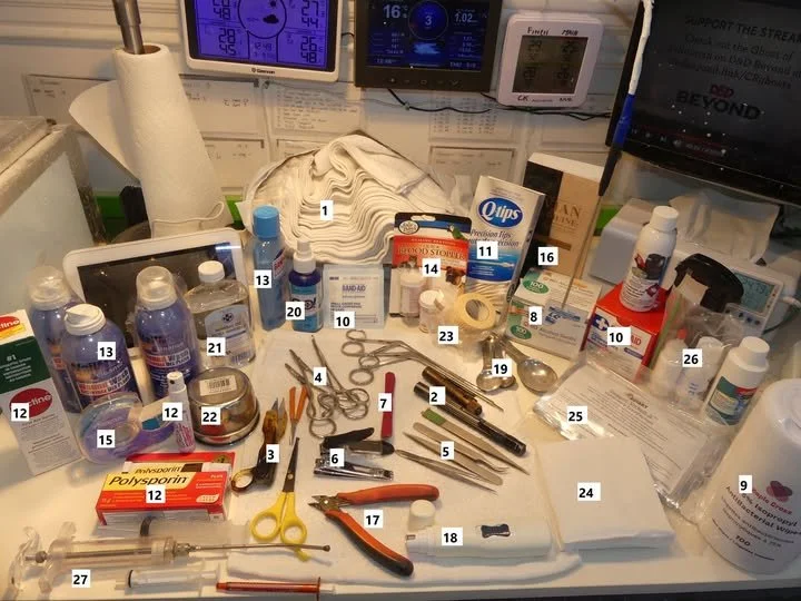 Medical supplies and tools arranged on a hospital tray, including bandages, scissors, scalpels, forceps, antiseptics, medications, and other medical instruments.