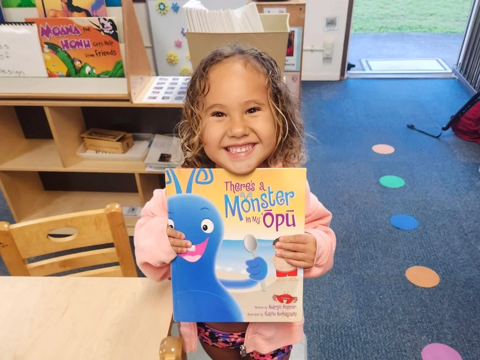 Little girl with author Karyn Hopper's children's book