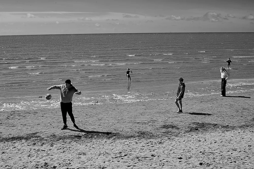 northwest-coast-man-throwing-football-beach-bw.webp